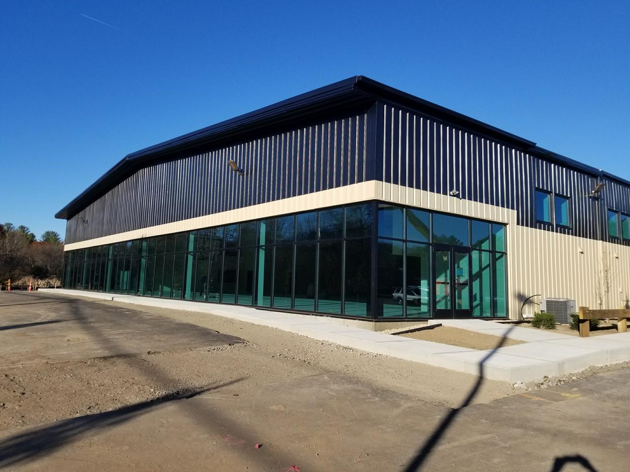 commercial-exterior-building-facade-with-glass-windows-surrounded-by-unpaved-parking-lot