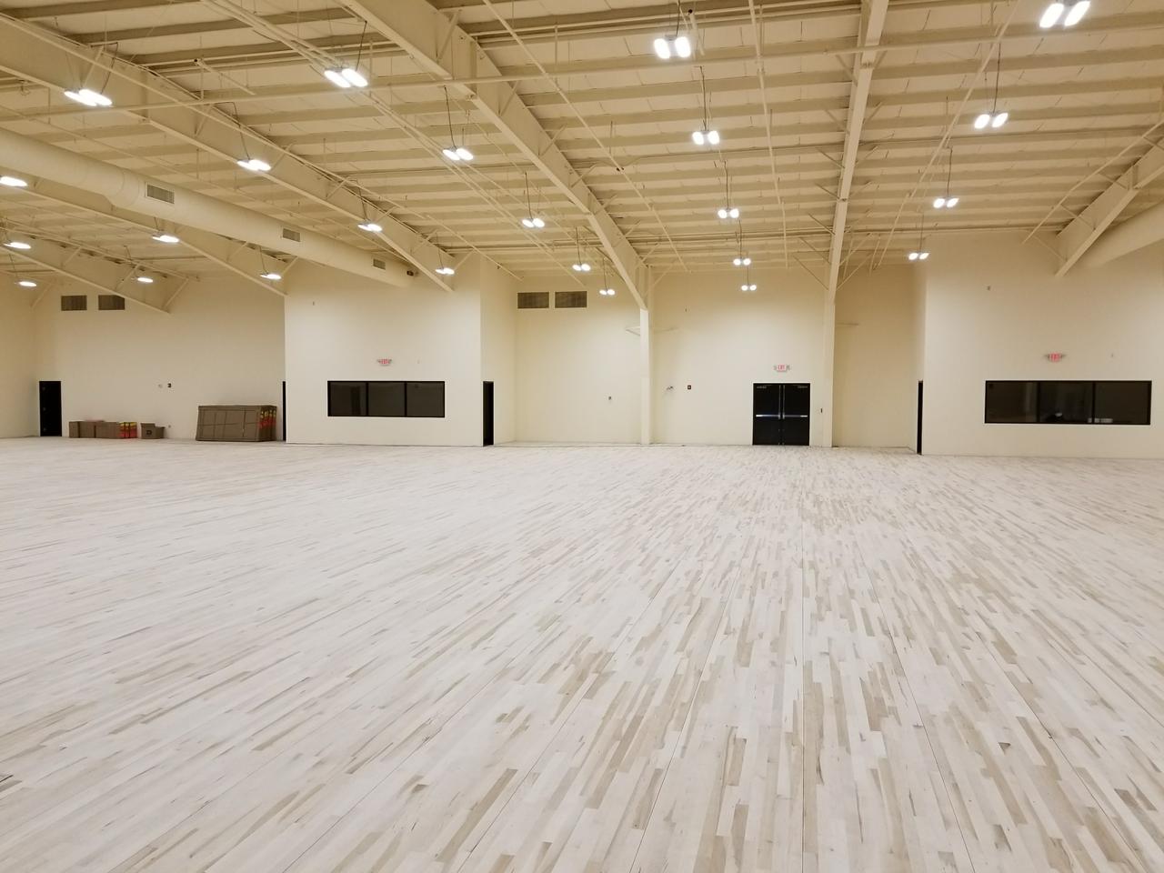 large-open-space-basketball-court-with-bright-lights-and-blond-wood-flooring