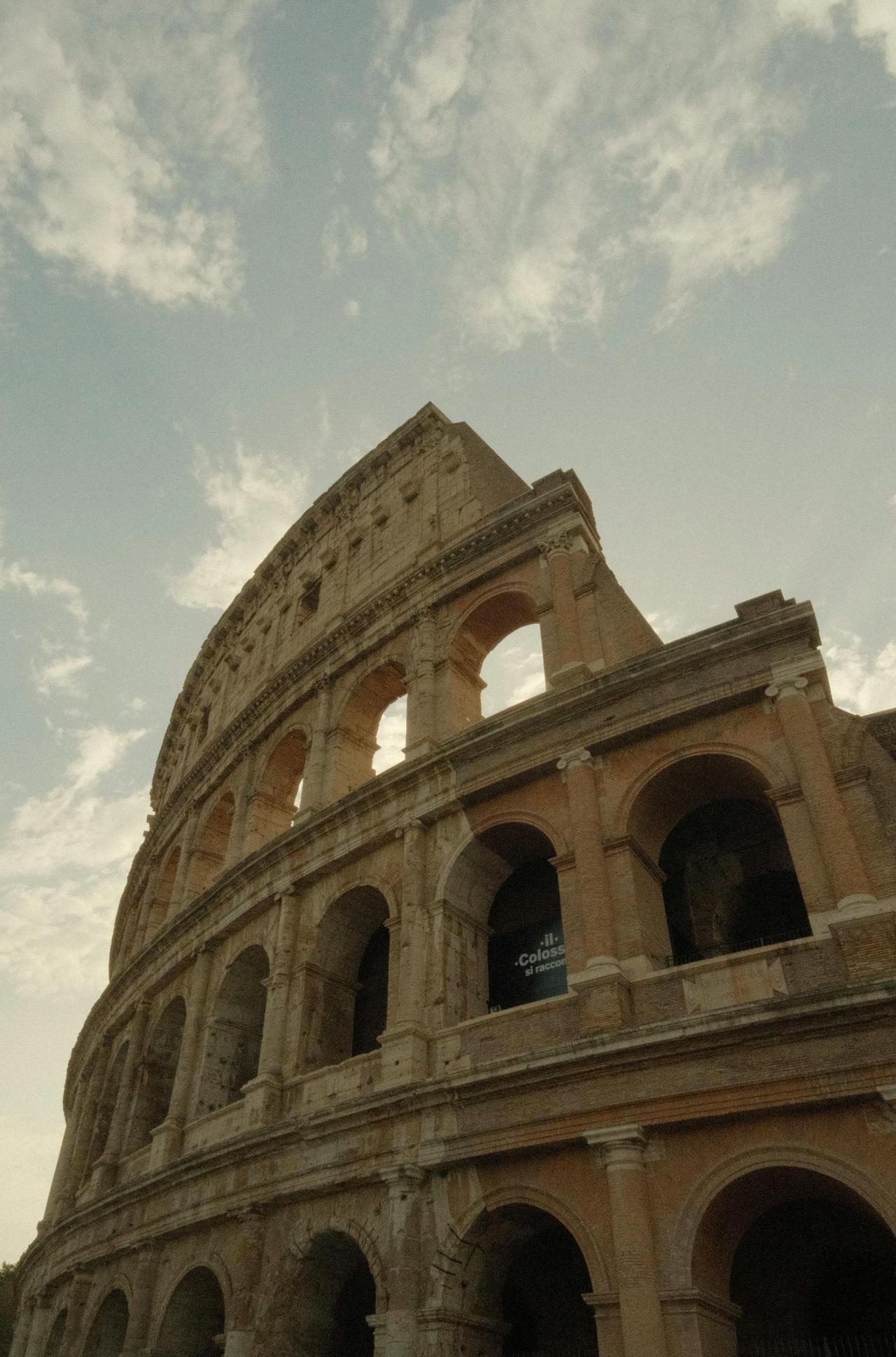 The majestic Colosseum in Rome stands tall under a dramatic cloudy sky.