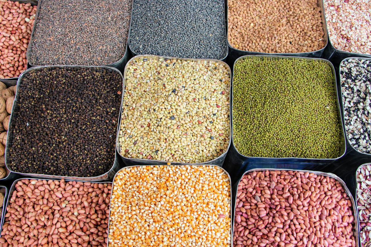 A colorful assortment of spices and legumes displayed at a Nepalese market, showcasing the variety in local cuisine
