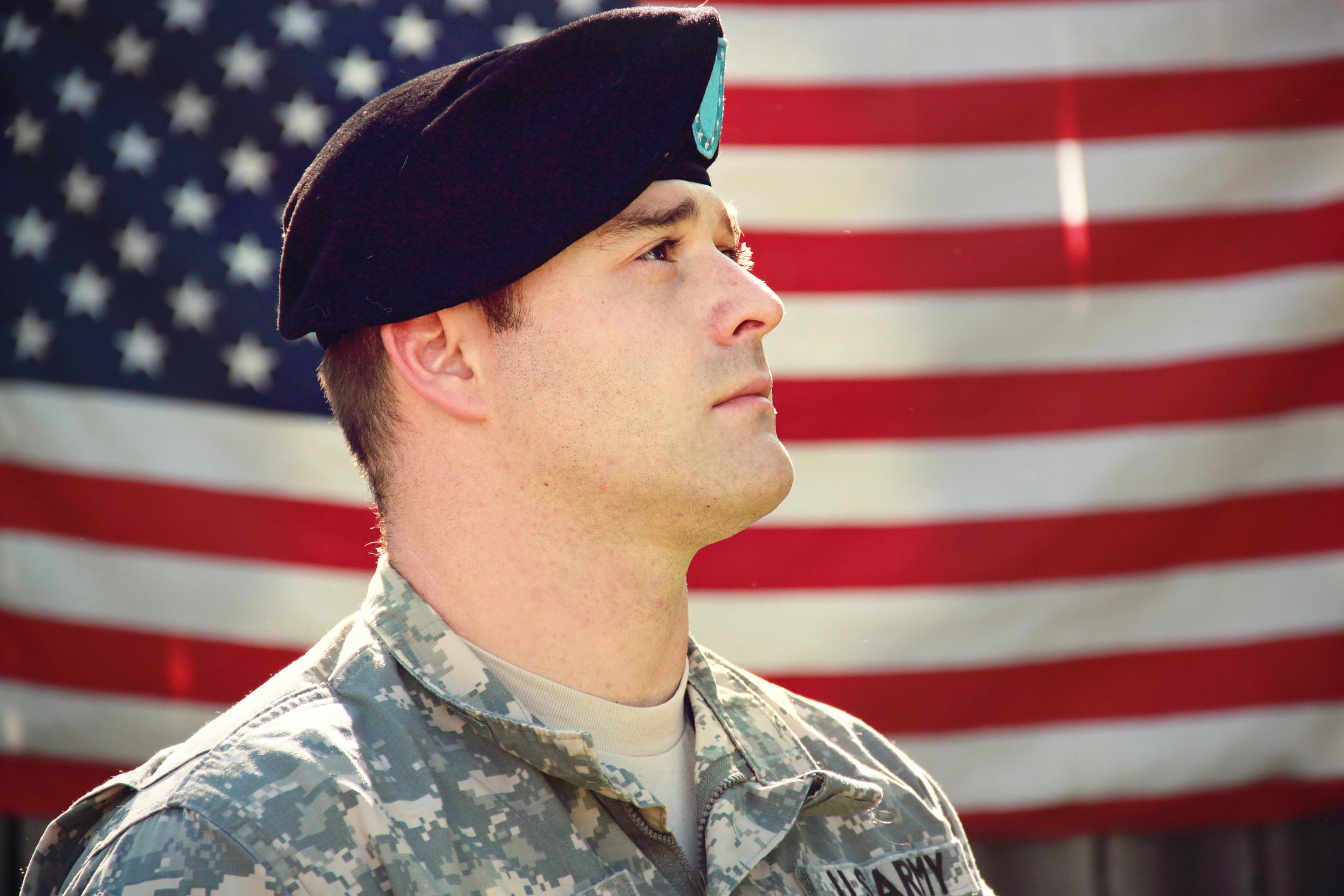 man-wearing-combat-hat-and-top-looking-up-near-flag-of-1202726.jpg