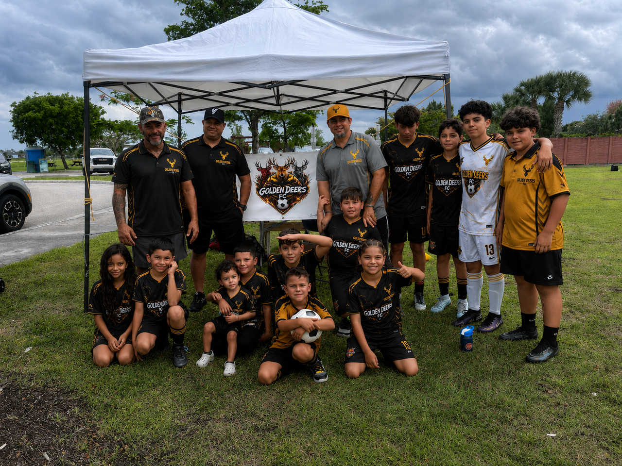 Young soccer players in Golden Deers FC uniforms playing together at the park during match