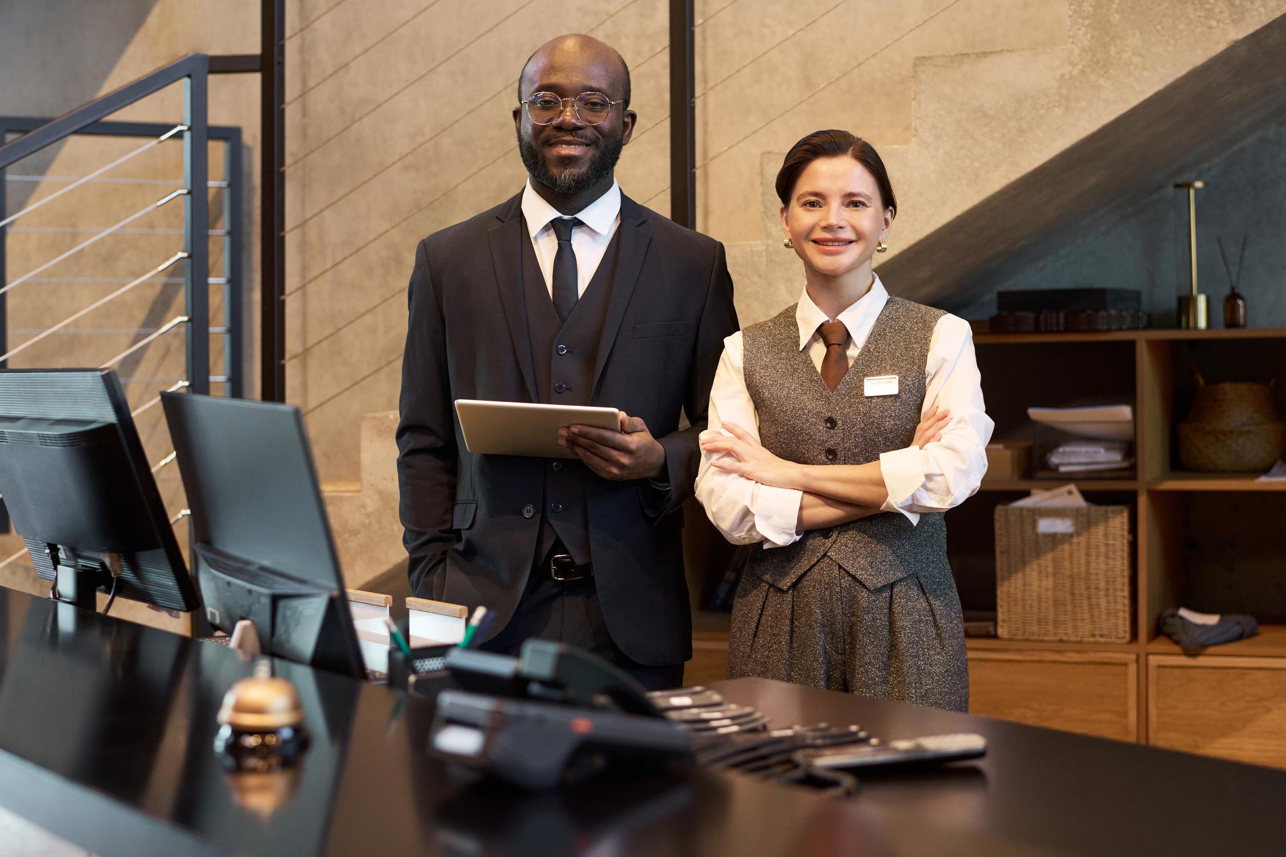 smiling-hotel-staff-welcoming-guests-at-reception-2025-05-27-23-10-21-utc.jpg