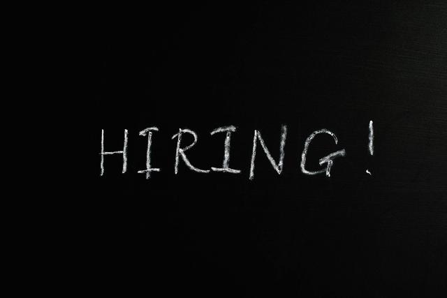 Close-up of the word 'Hiring!' written in white chalk on a blackboard, ideal for recruitment themes.