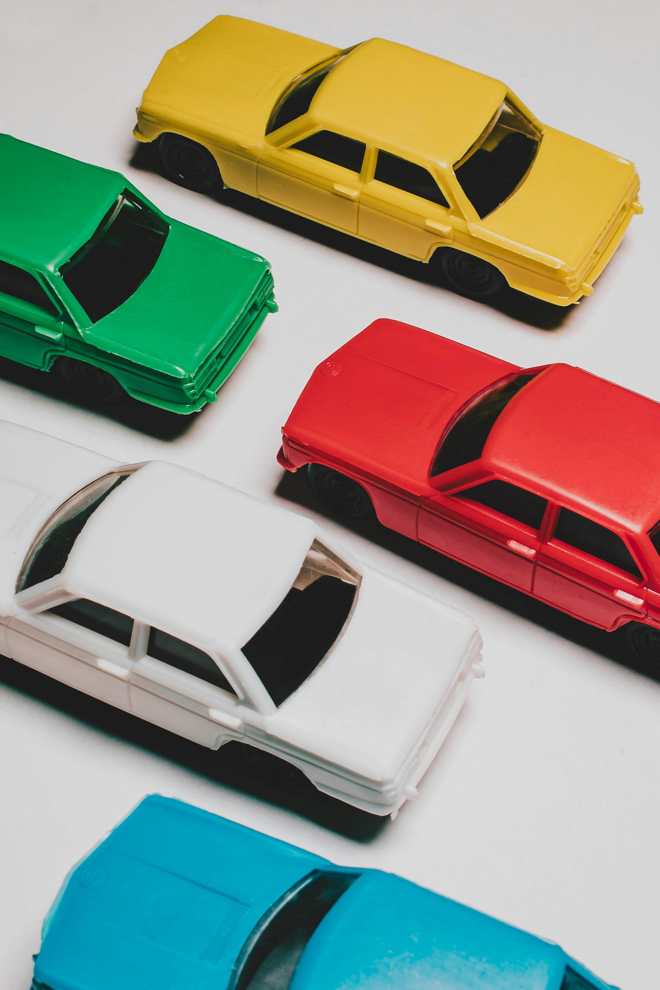 Arrangement of Color plastic cars on white background