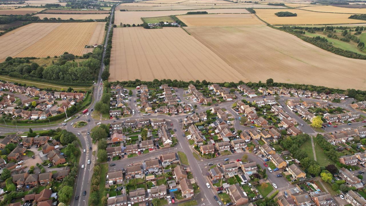 Drone shot showing a residential area and farmlands in Luton, UK.