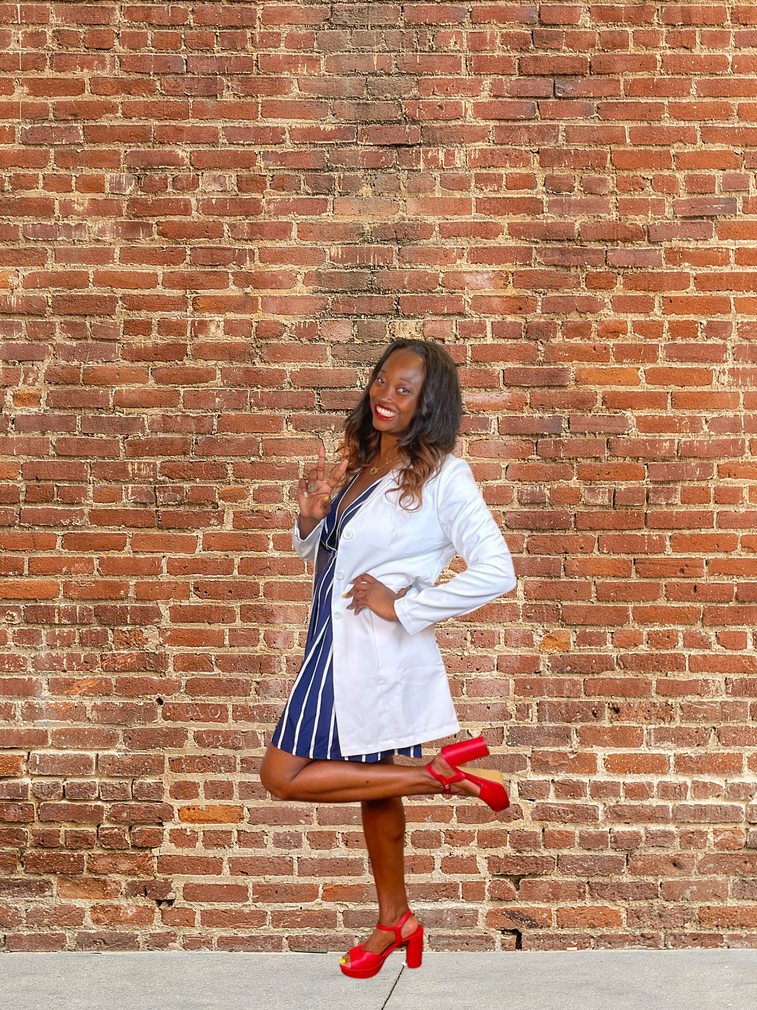 Dr. Cee Nicole in front of a brick wall
