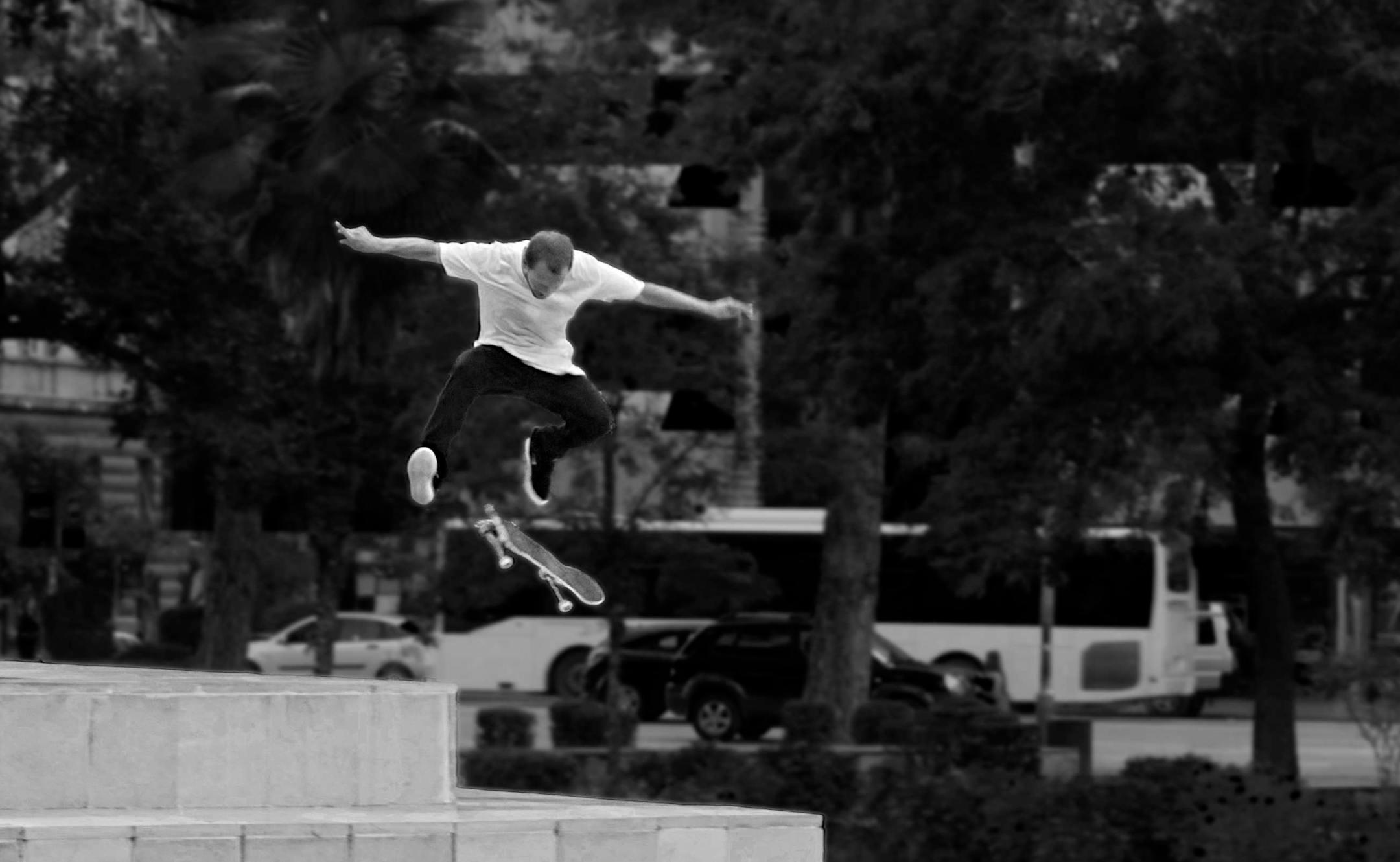 Black and white photo of a skateboarder mid-air in Tirana, Albania.