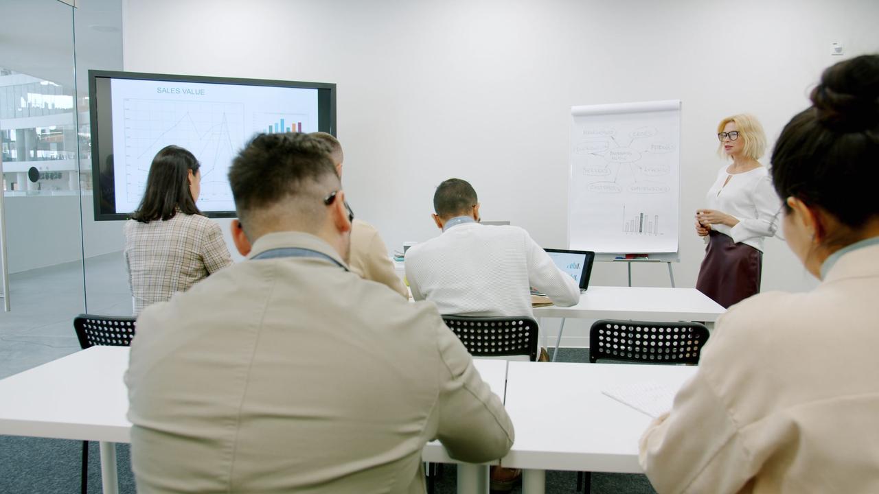 A business professional presenting in a modern, well-lit office environment.