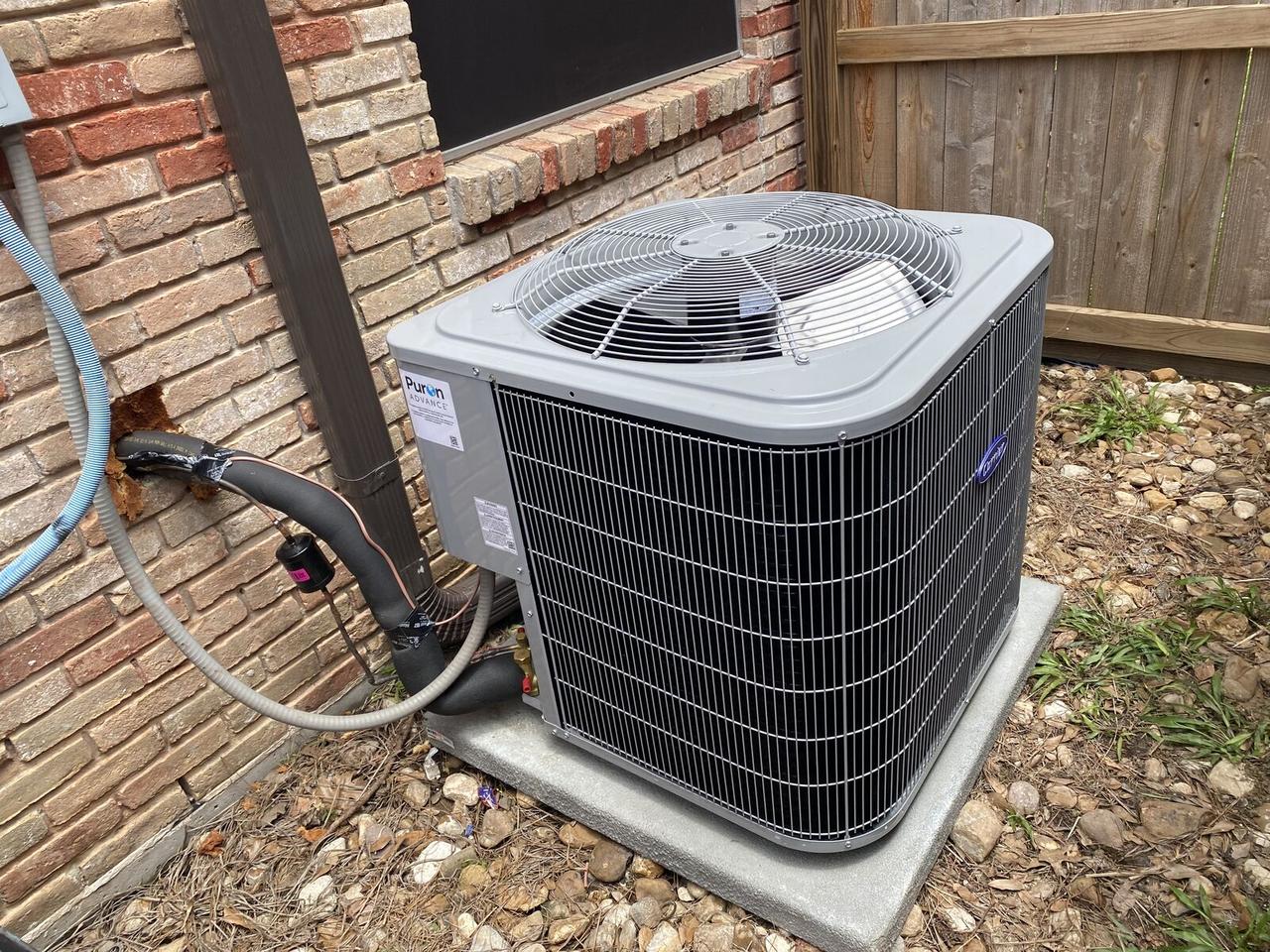 Carrier Puron Advance AC condenser on a new concrete pad after installation in Spring, TX