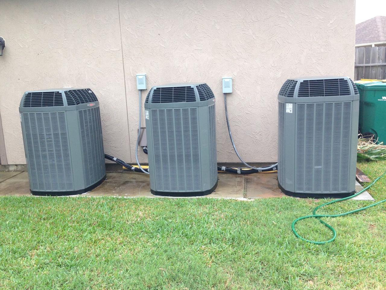 Three Trane AC condensers installed side by side at a large home in Spring, TX