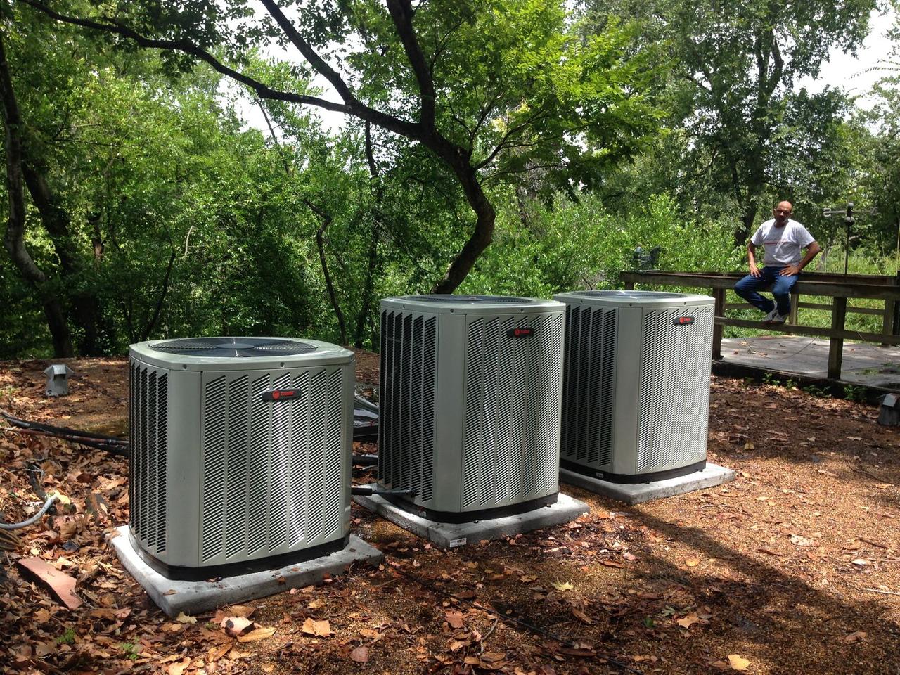 Three Trane condensers on new pads at a wooded property in Spring, TX