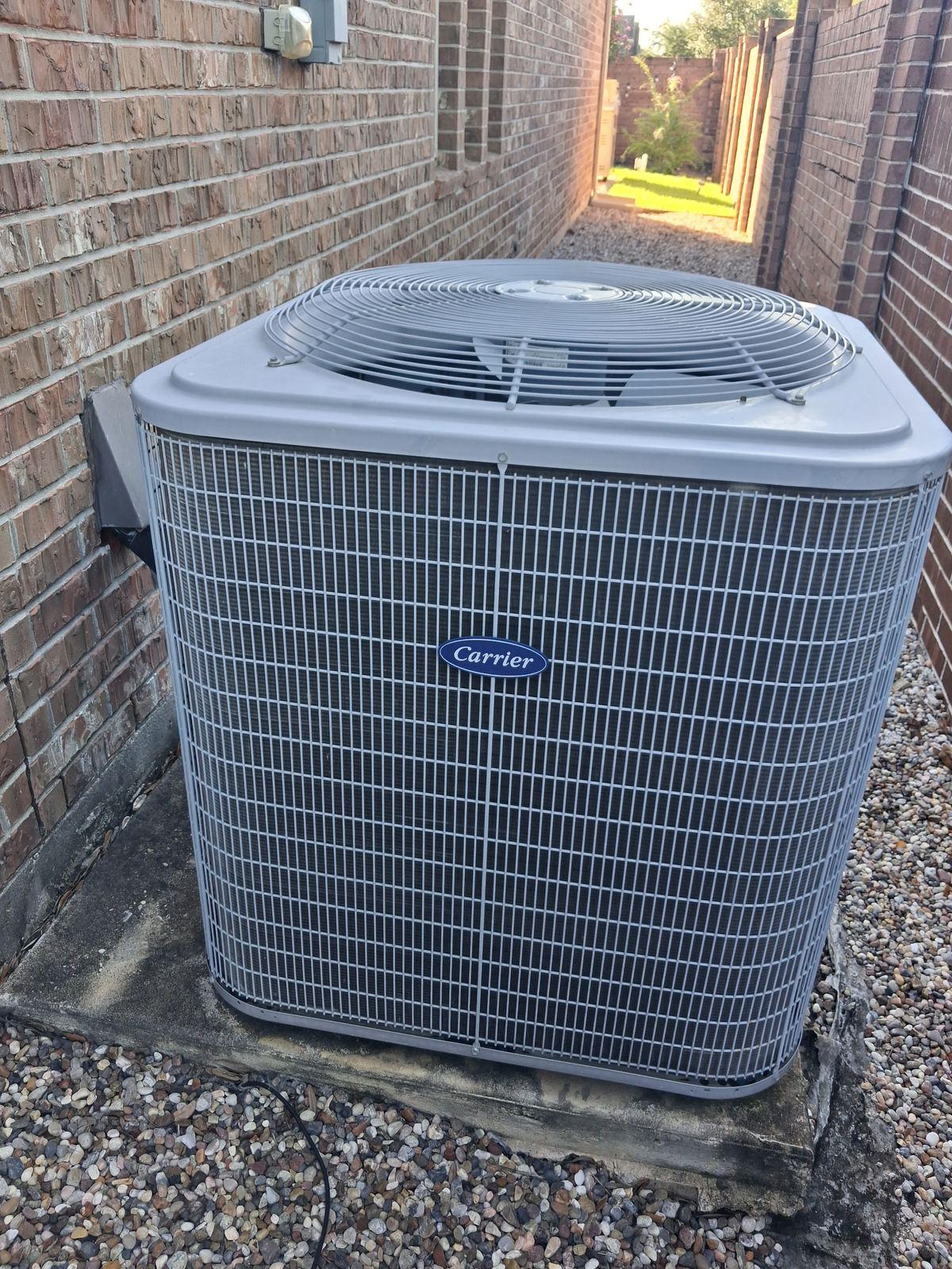 Old single-stage AC condenser before replacement in Spring TX backyard