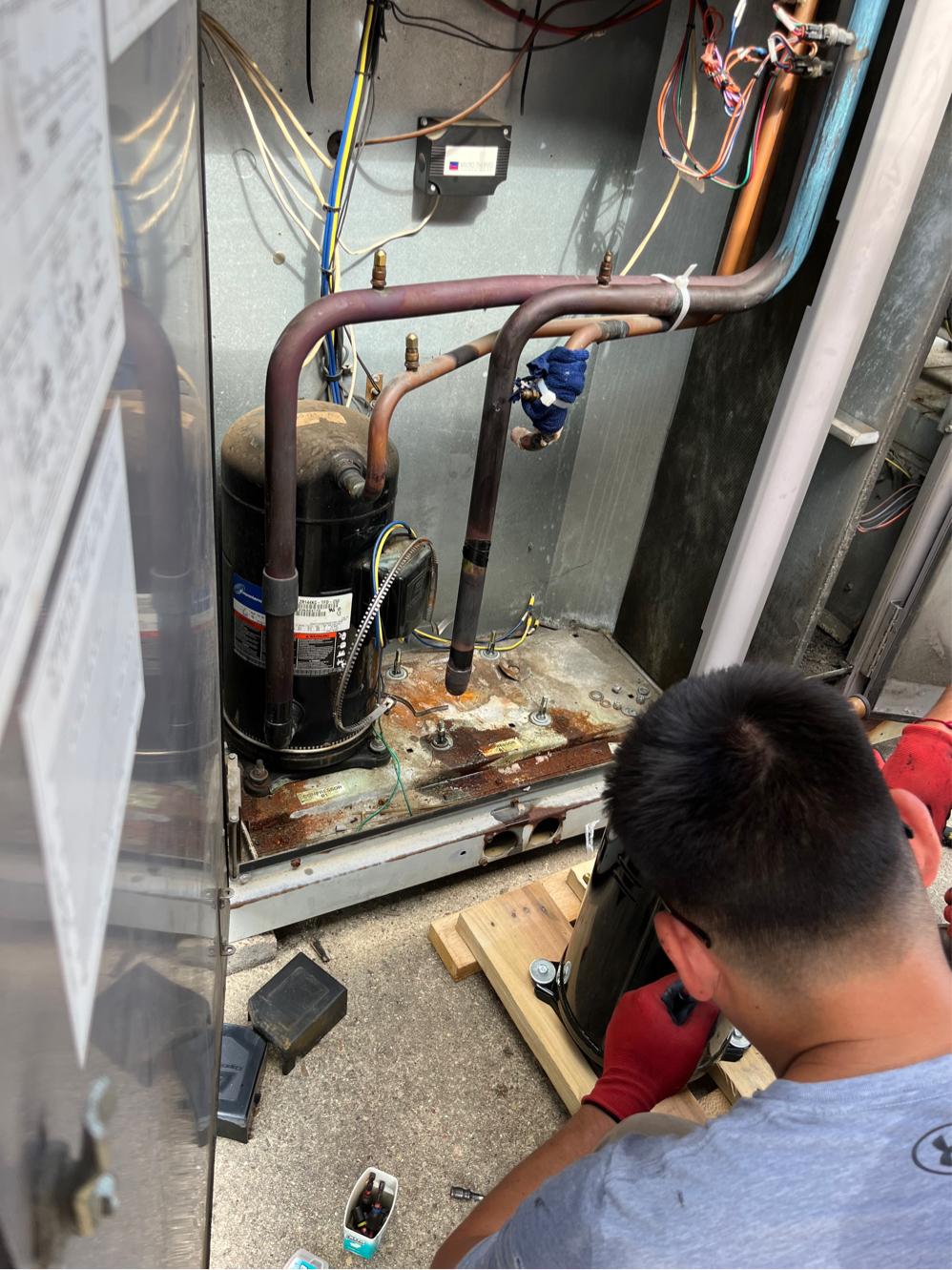 Failed compressor still installed with corroded mounting pan before replacement