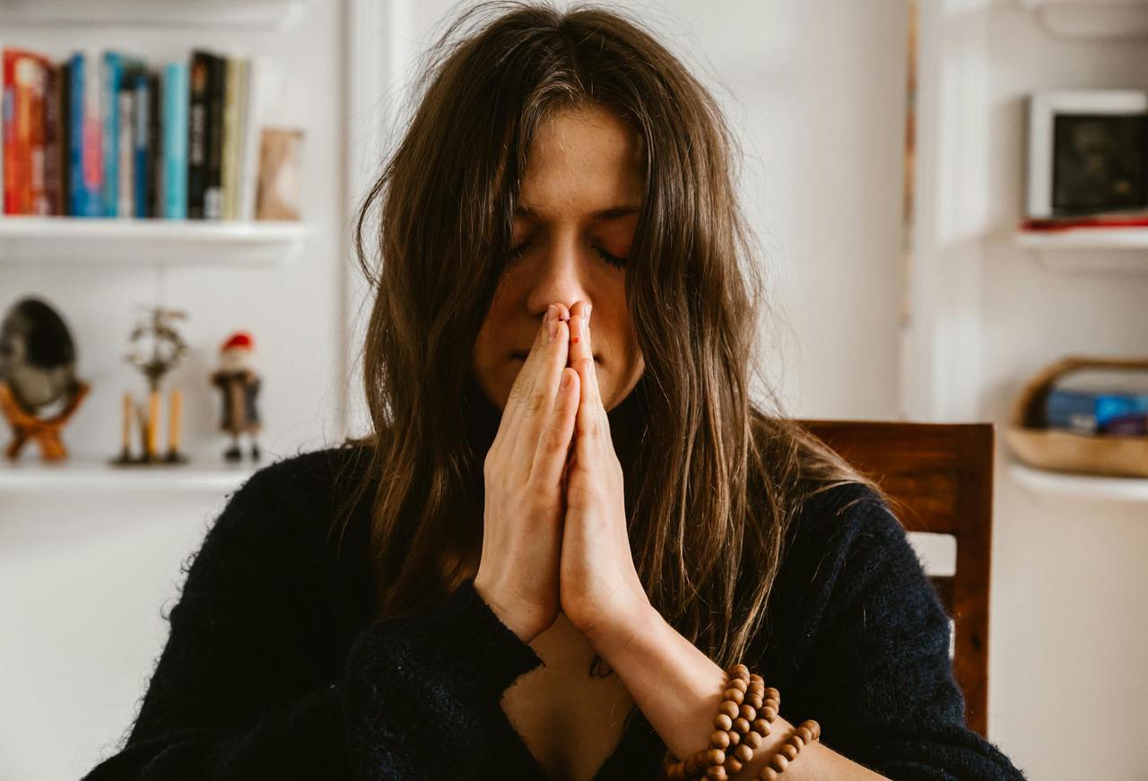 Woman practicing meditation indoors, highlighting calmness and mindfulness.
