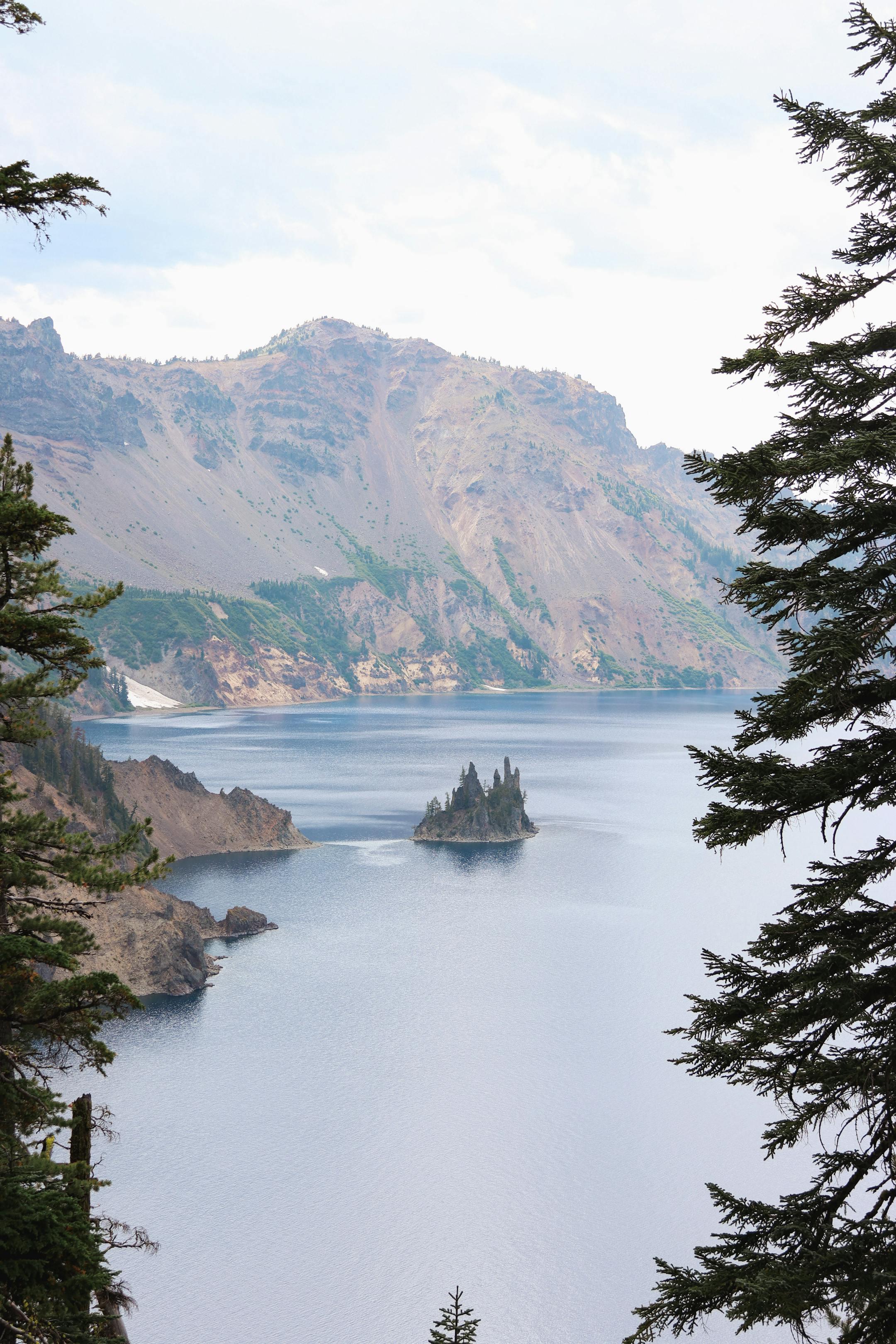 Stunning aerial view of Crater Lake with lush trees and mountains in Oregon.