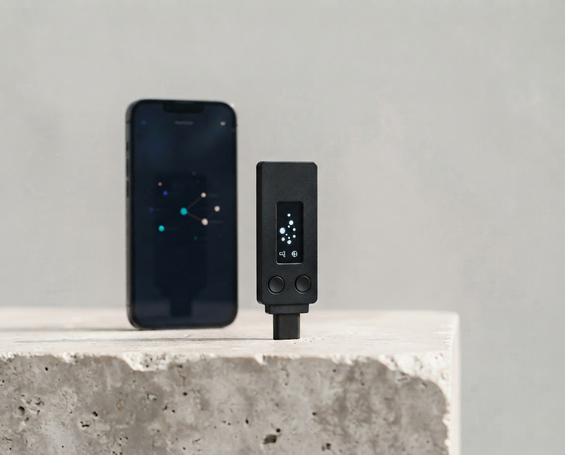 A hardware wallet and phone on a studio pedestal