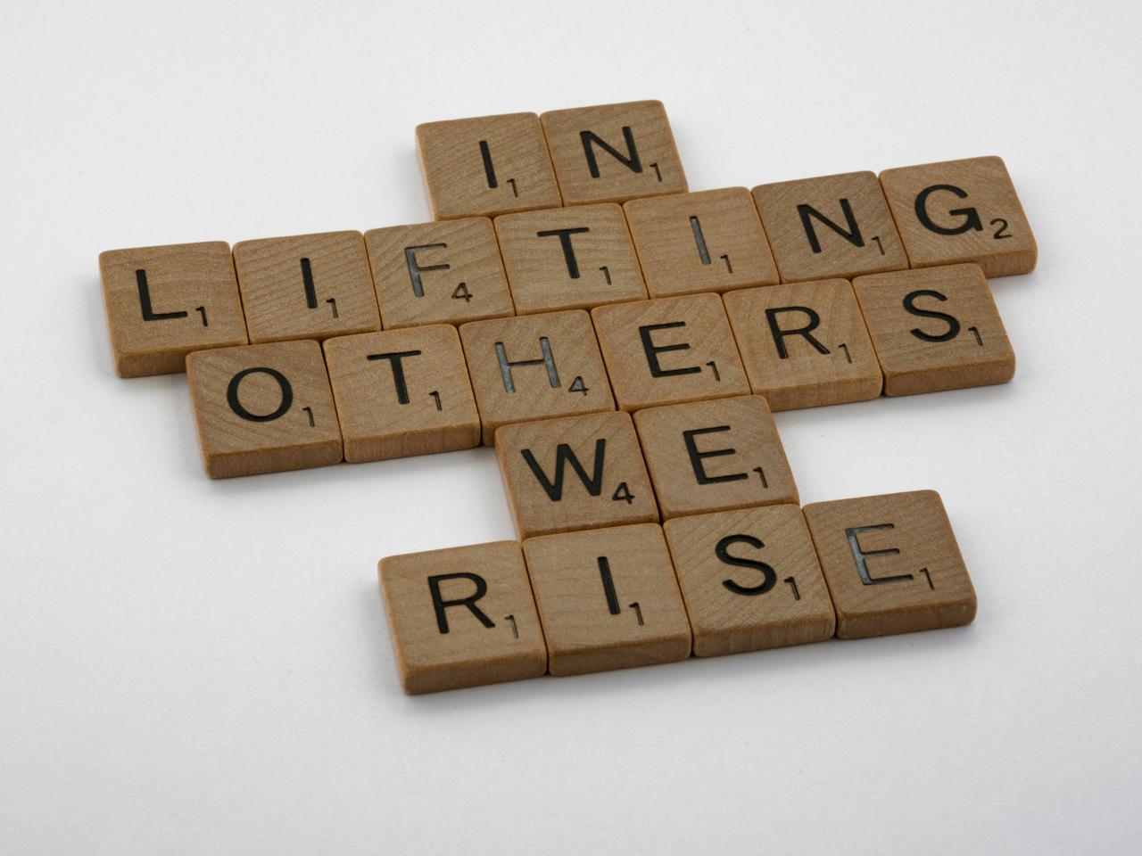 scrabble, scrabble pieces, lettering, letters, wood, scrabble tiles, white background, words, quote, letters, type, typography, design, layout, in lifting others we rise, help people, teamwork, team, share, community, fellowship, love, good samaritan, 