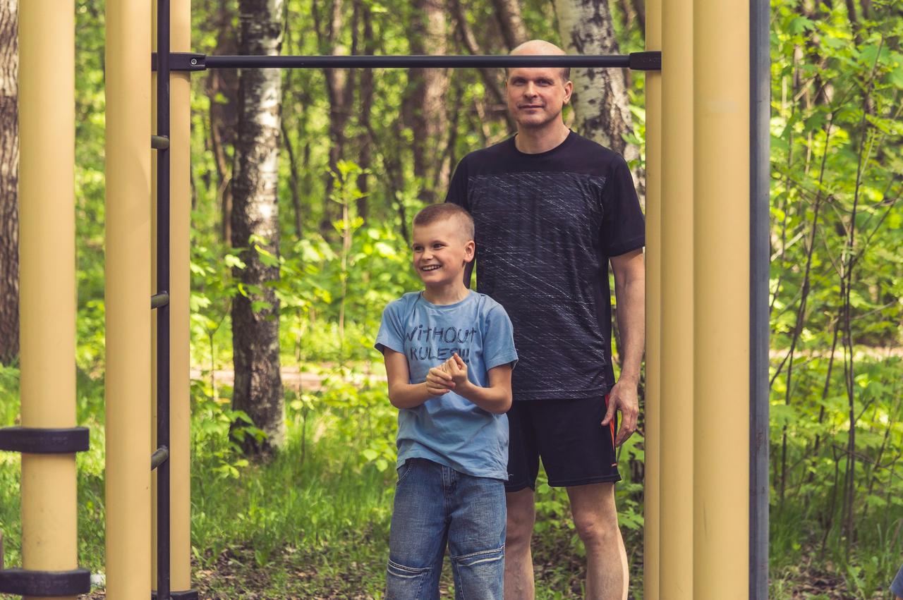 father helping boy train in the park