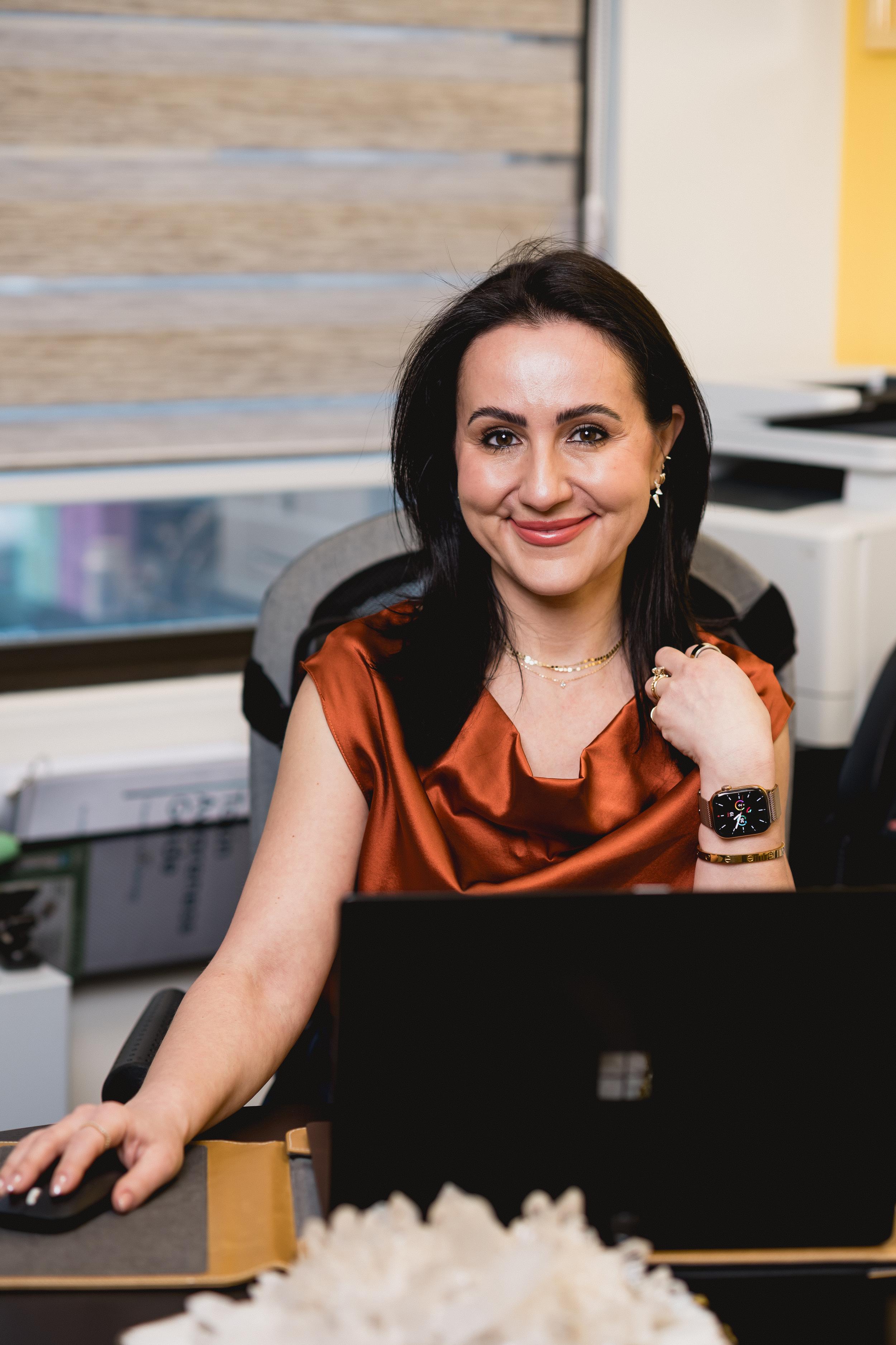 inessa-makdulina-nyzio-functional-medicine-provider-stamford-ct-office-desk.jpg<br>Inessa Makdulina-Nyzio, functional medicine provider in Stamford, CT, seated at her office desk reviewing client notes on her computer.