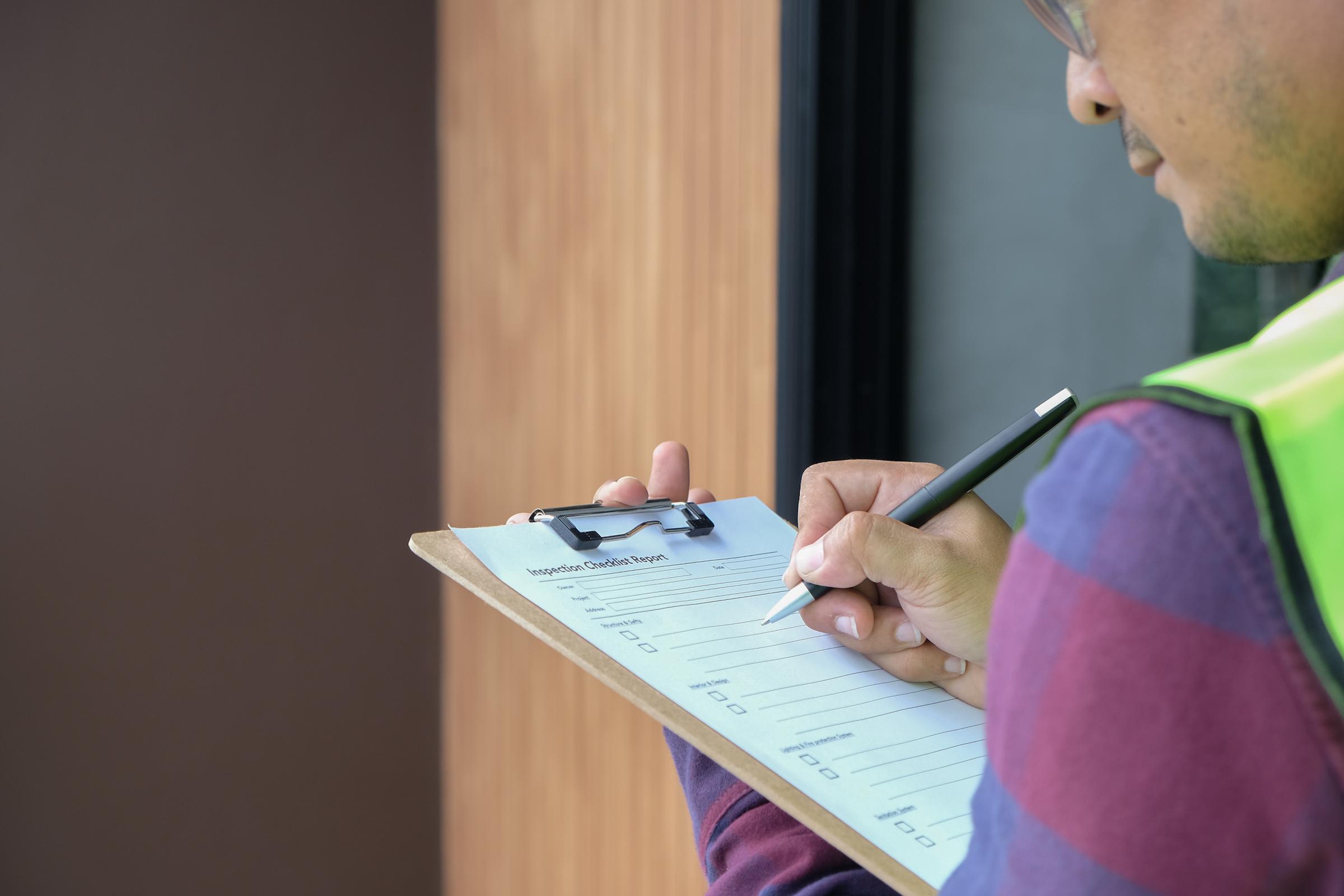 A man with a clipboard inputting information.