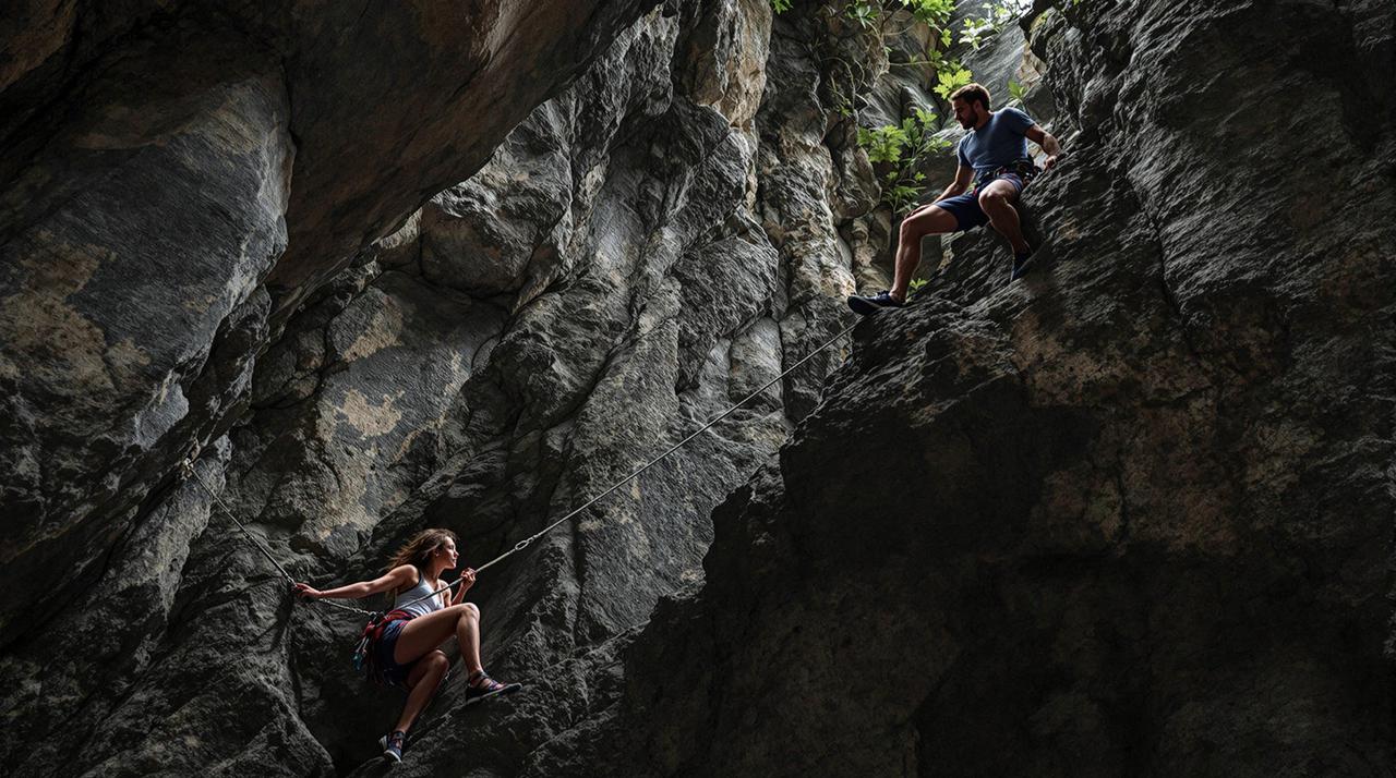 2 friends climbing a rocky cliff together within the ominous and spooky temple cave. but the 2 friends are chained together. the two have to take turns swining their momentum to get farther up and through the rocky cliff withi.png