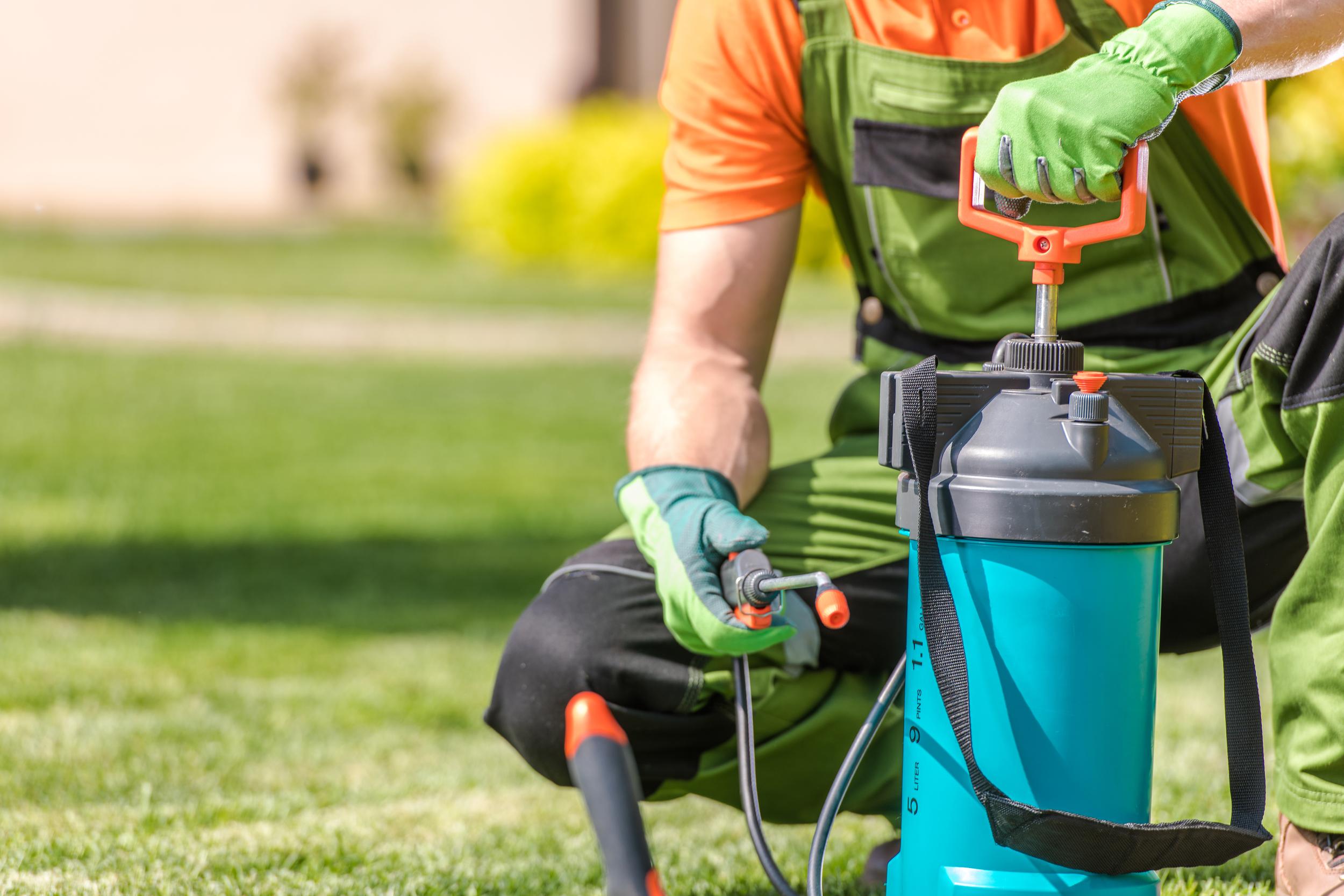 gardener-using-sprayer-on-lawn-in-green-overalls-2026-09-24-08-07-44-utc.jpg