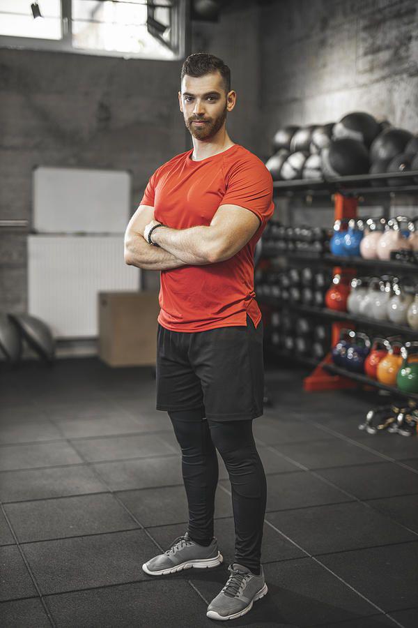 portrait of young male fitness trainer in the gym by djordjedjurdjevic.jpeg