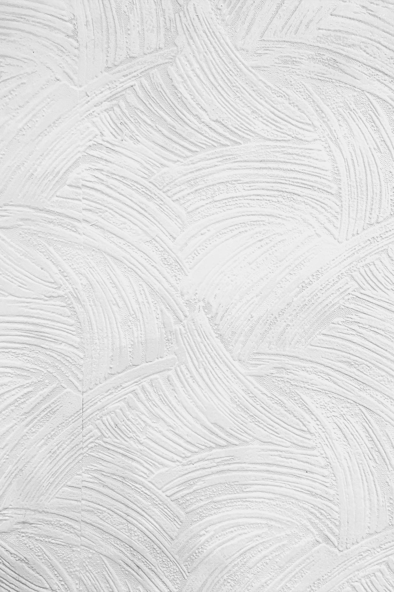 Minimalistic textured white plaster wall ideal for backgrounds and designs.
