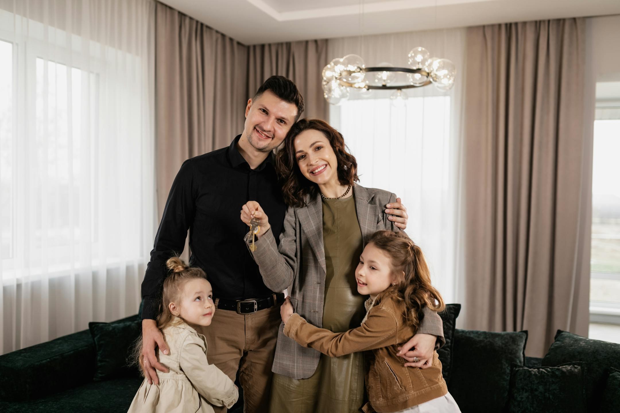 A joyful family holding keys, celebrating their new home indoors.