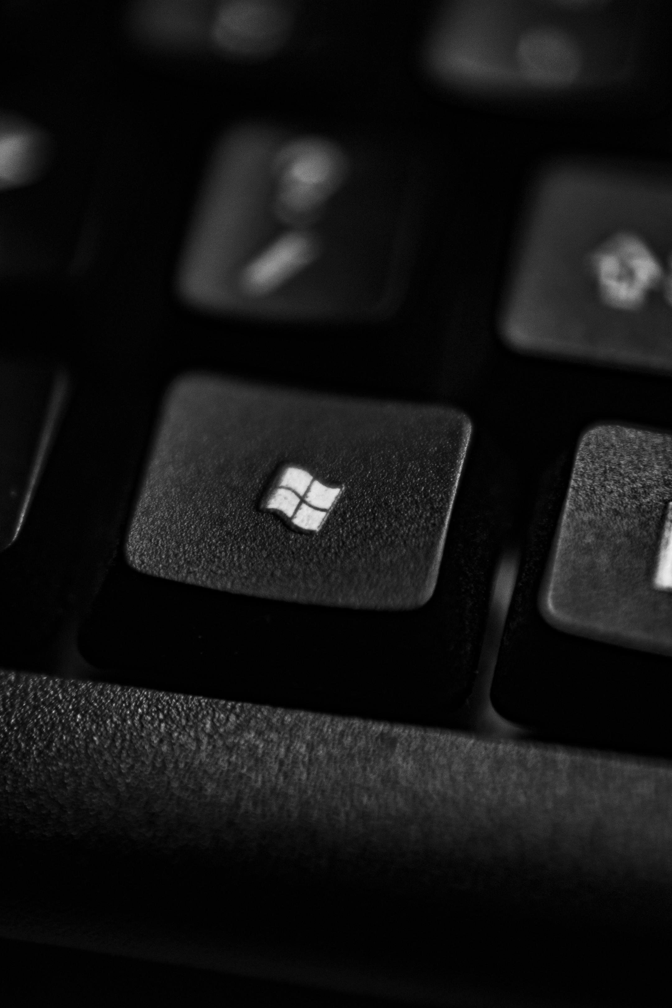 High-quality close-up of a Windows logo key on a black plastic keyboard.
