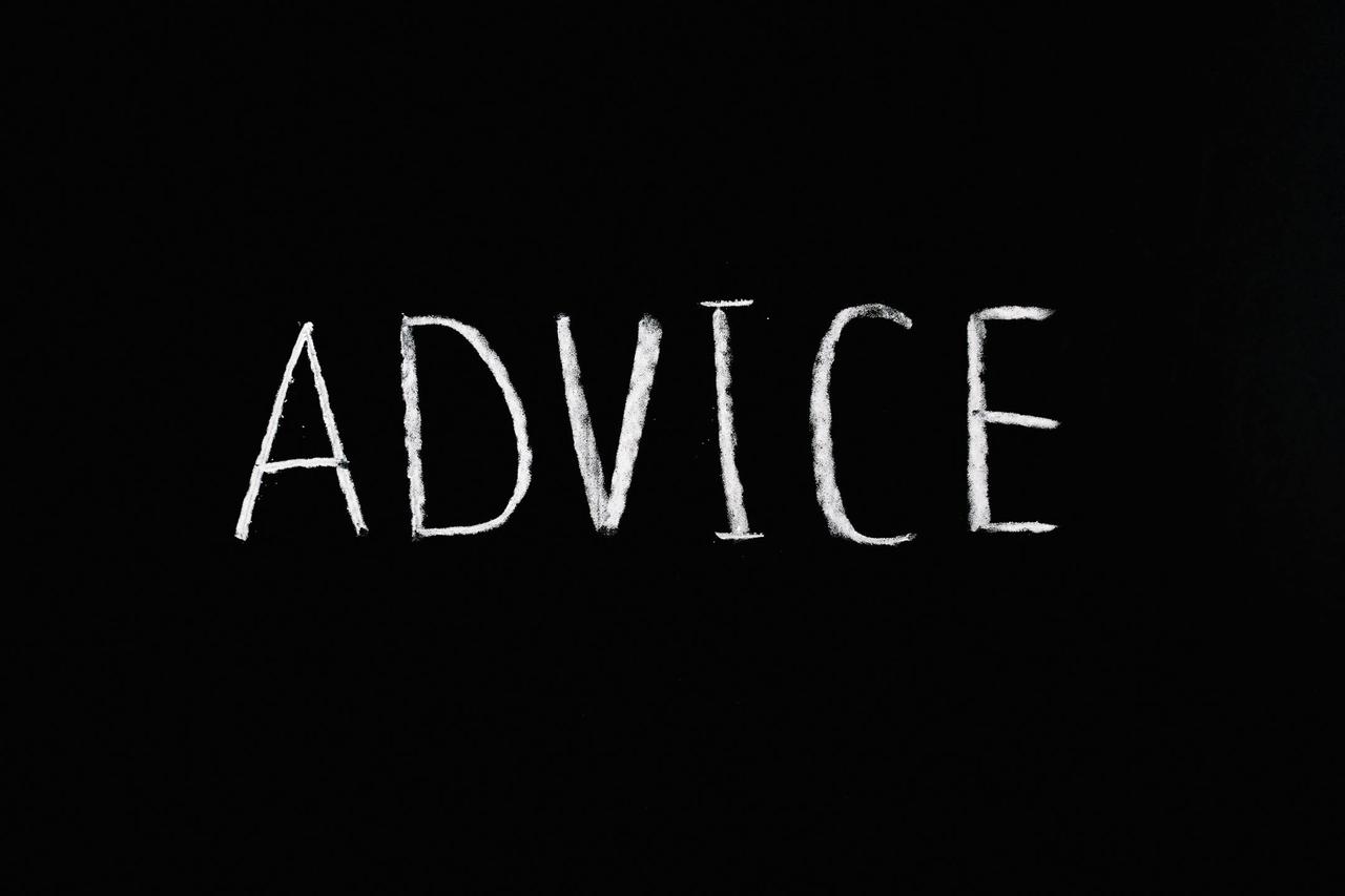 Inspirational word 'Advice' written in white chalk on blackboard.