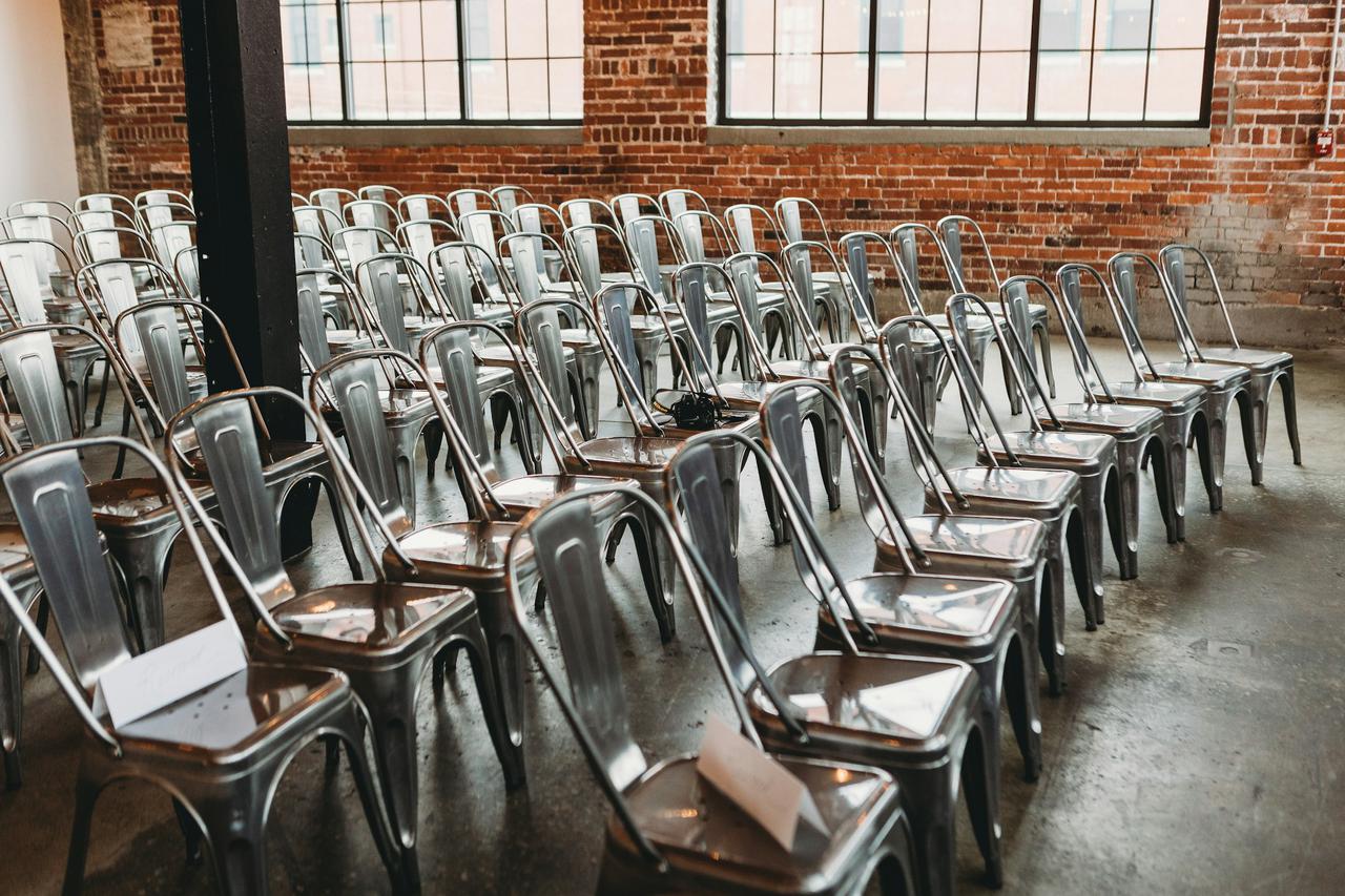 Metal chairs lined up in a brick building