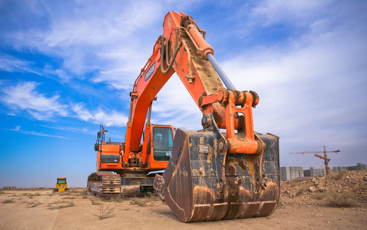 low-angle-photography-of-orange-excavator-under-white-clouds-1078884.jpg