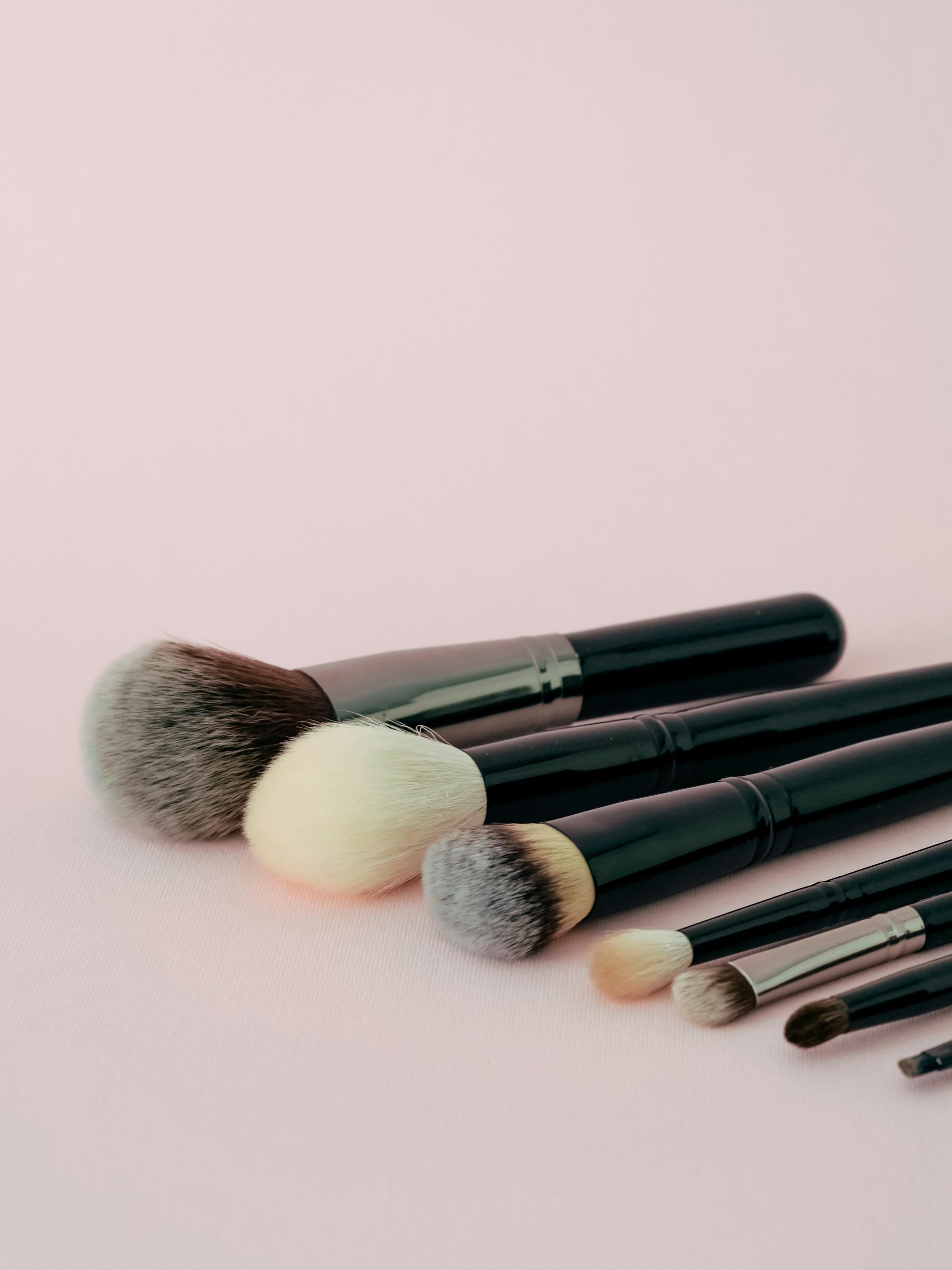 Set of makeup brushes on a pink background