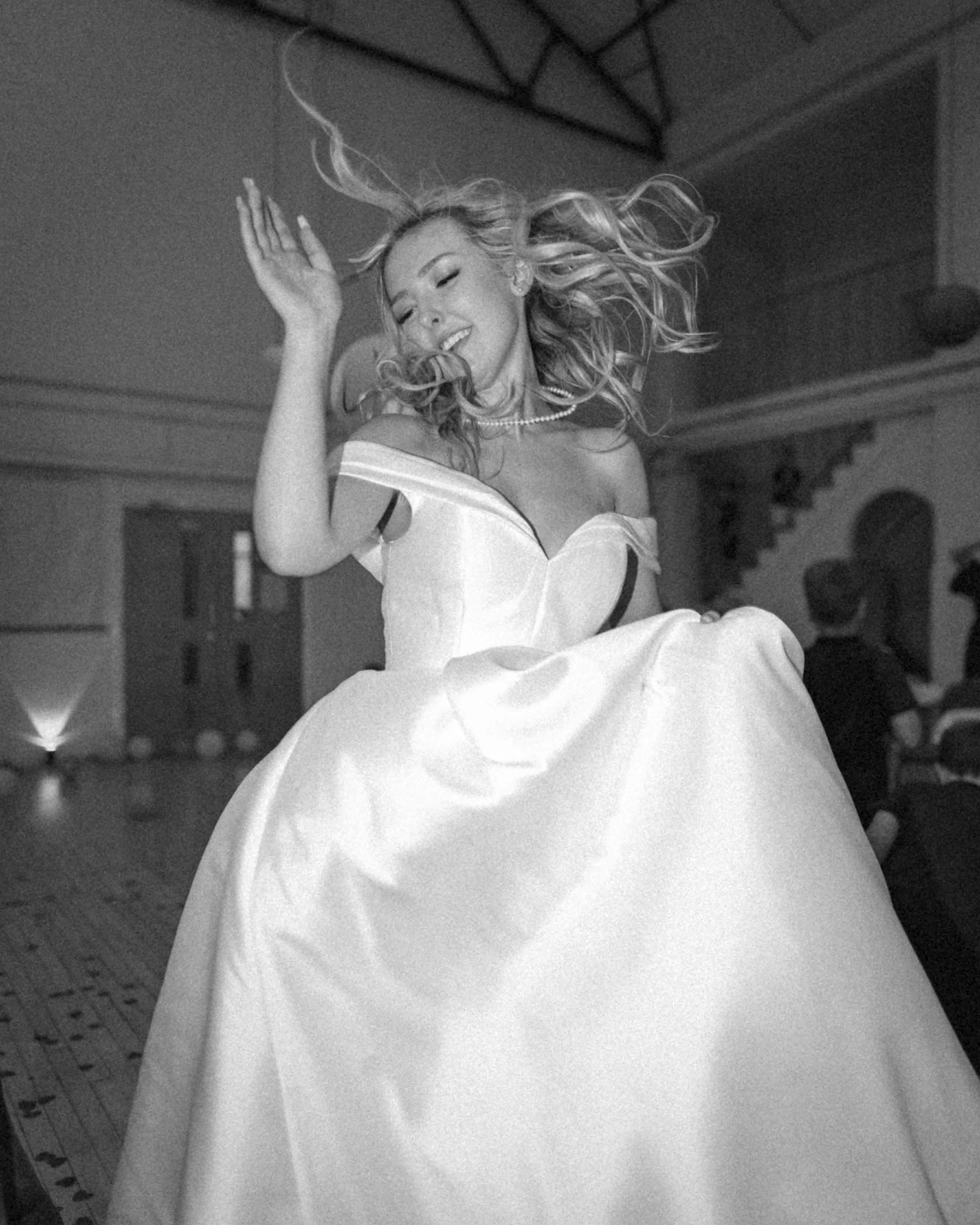 bride dancing at her reception with flash