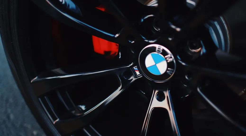 Gros plan d'une jante noire en alliage BMW avec un étrier de frein rouge