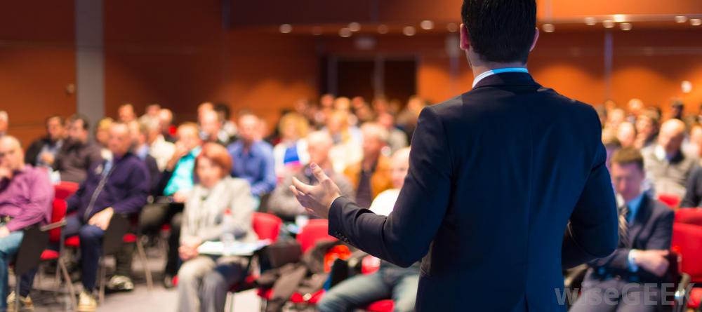 man-in-suit-speaking-to-audience-in-front-of-him.jpg
