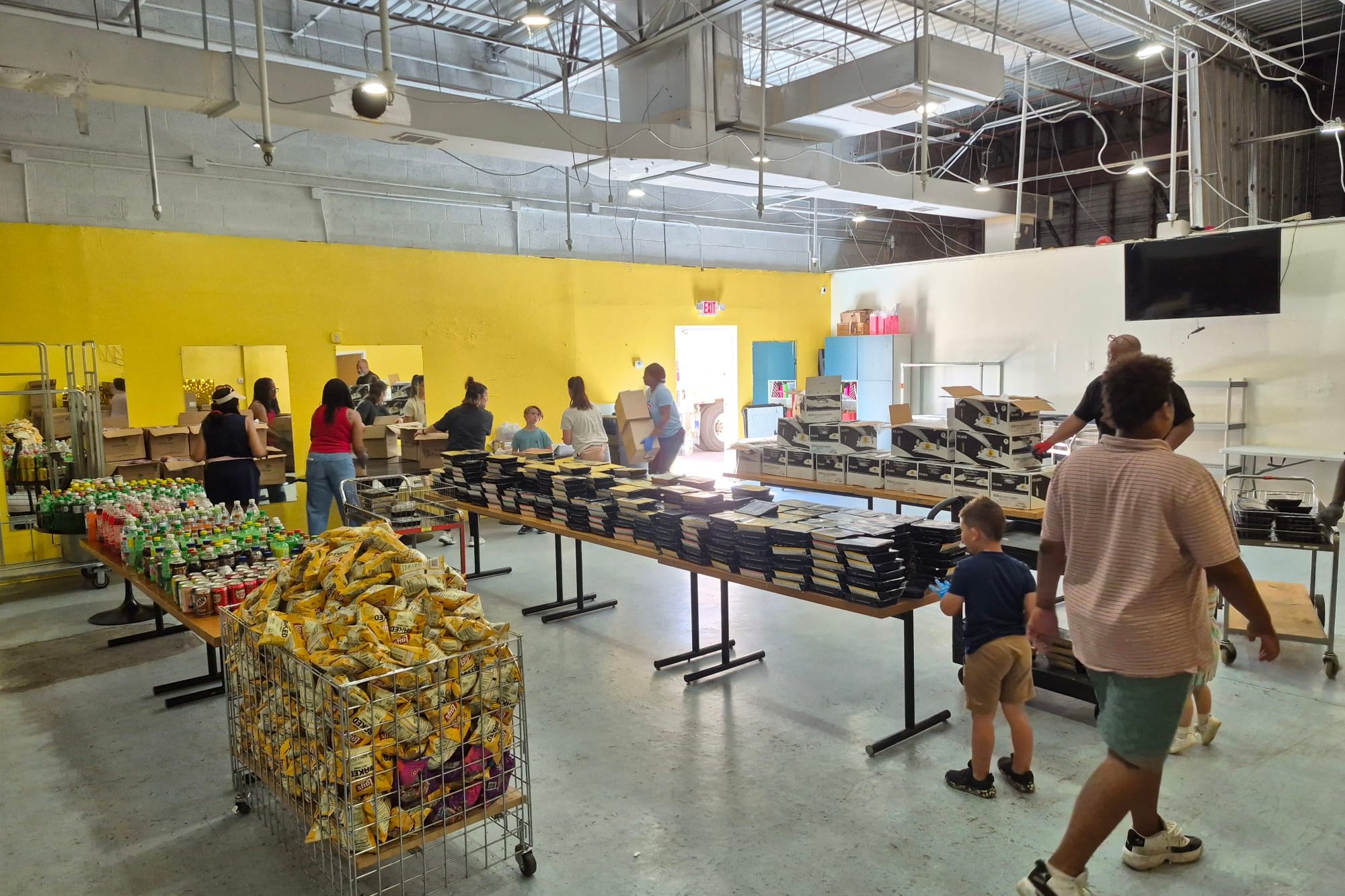 Families selecting groceries from stocked tables at the Brighter View food pantry in Glendale.
