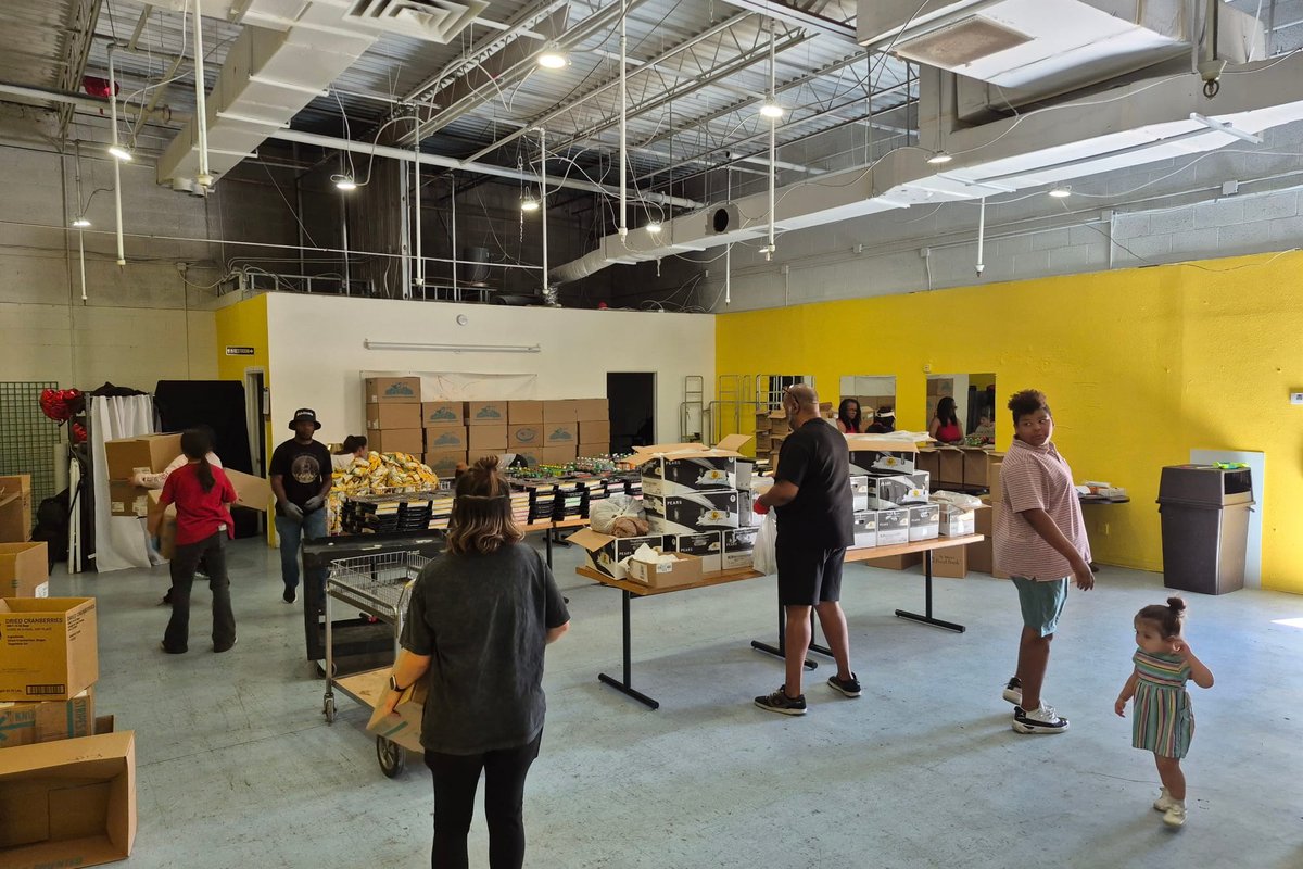 People selecting groceries at the pantry distribution tables.