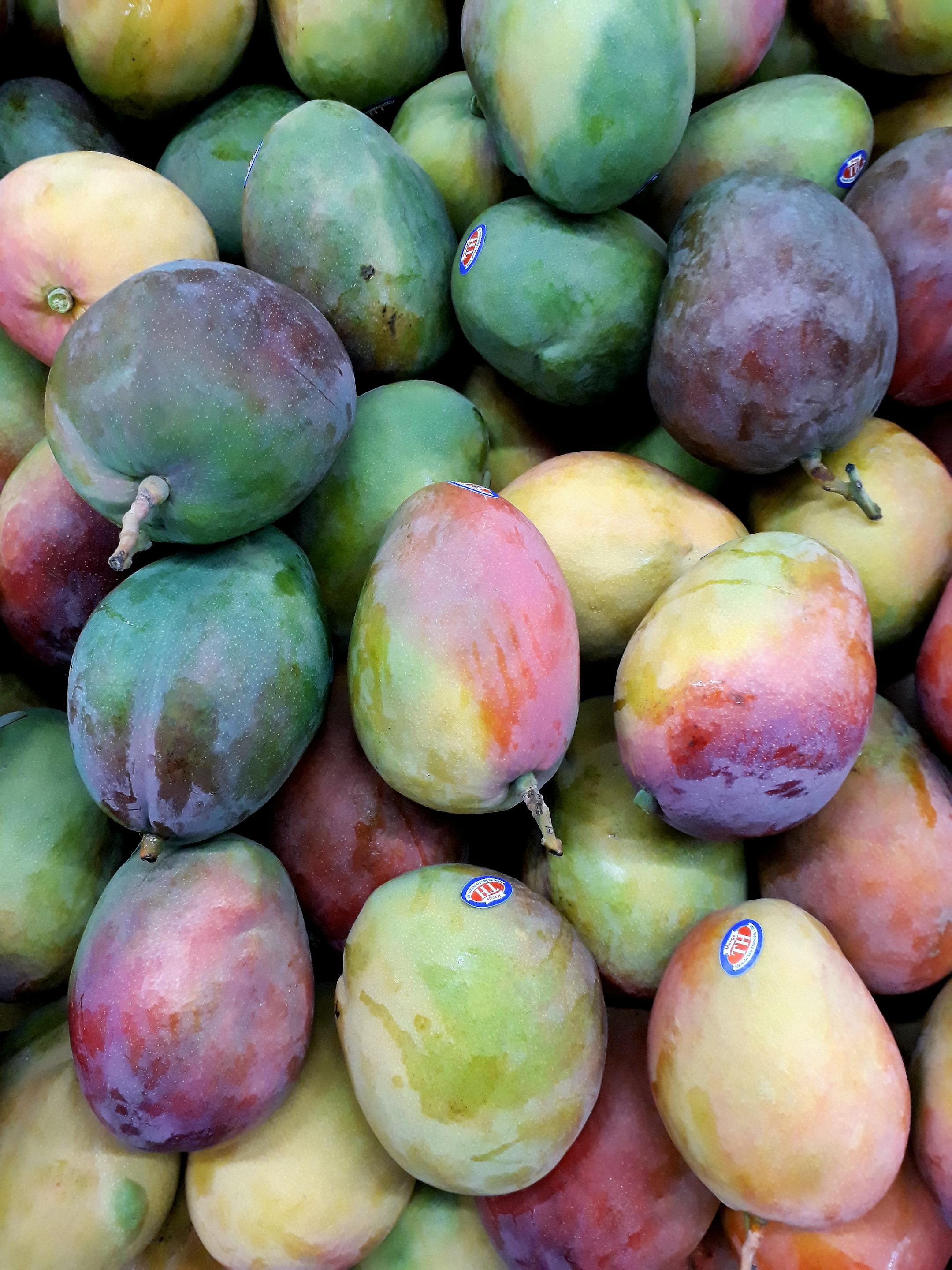 A vibrant collection of ripe mangoes stacked showcasing fresh produce.