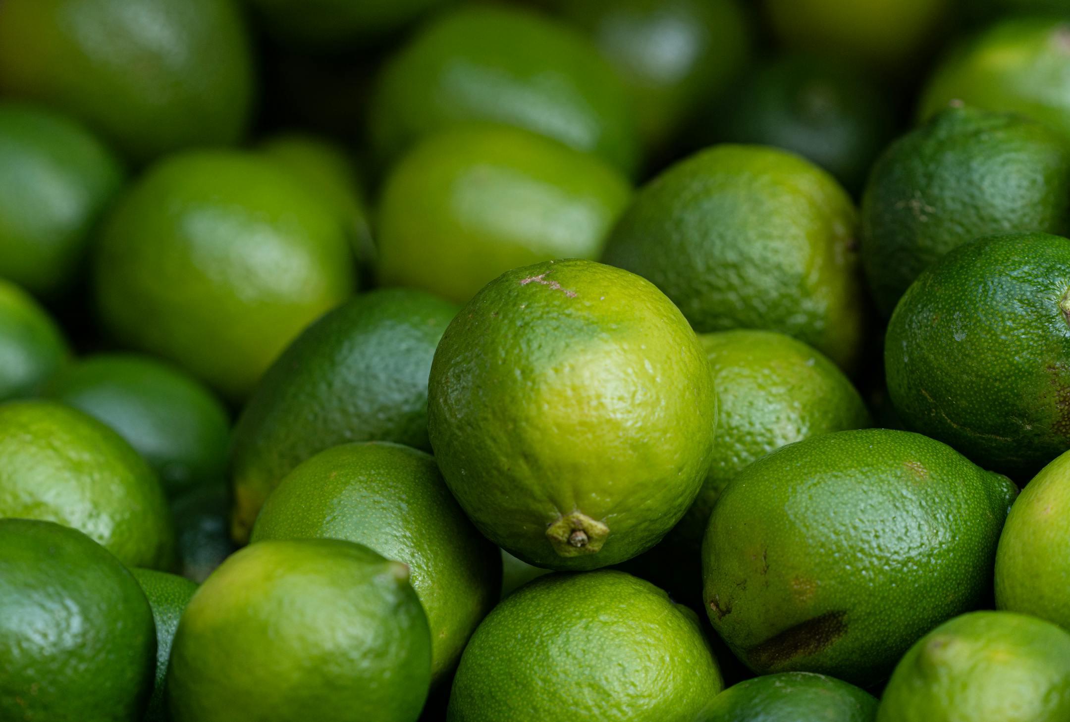 A vivid close-up of fresh limes showcasing their vibrant green hues and textures.
