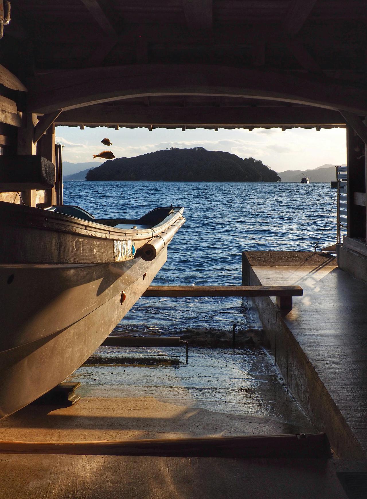 A tranquil lakeside boat dock with a boat, viewed at sunset. Ideal for travel and relaxation themes.