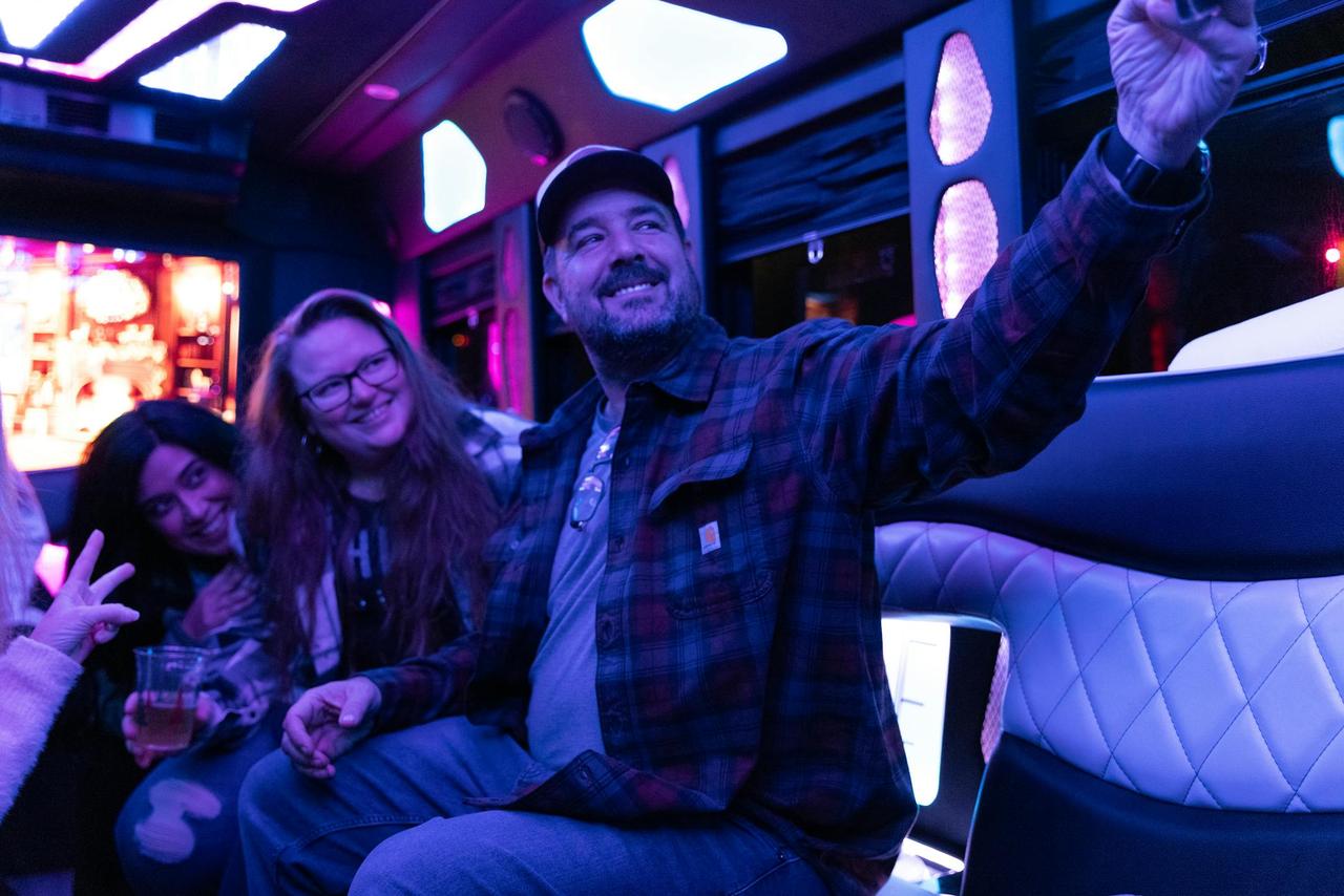 Friends taking a selfie inside a vibrant party bus, creating lasting memories.