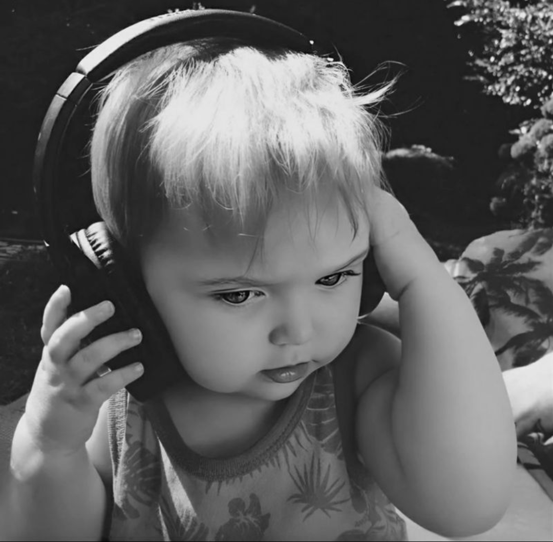 An intimate portrait of a person in their own world, headphones or absorbed in thought