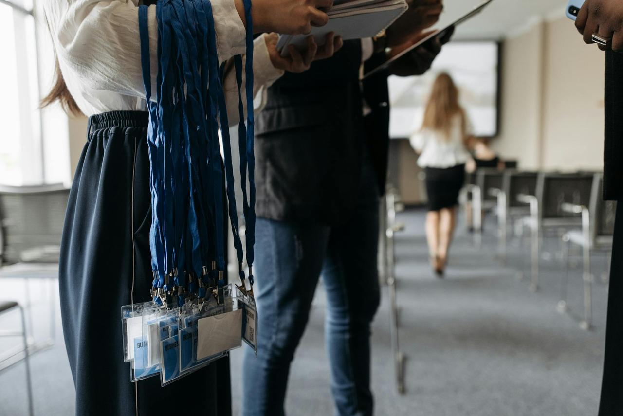 People in a conference room preparing with lanyards and badges.