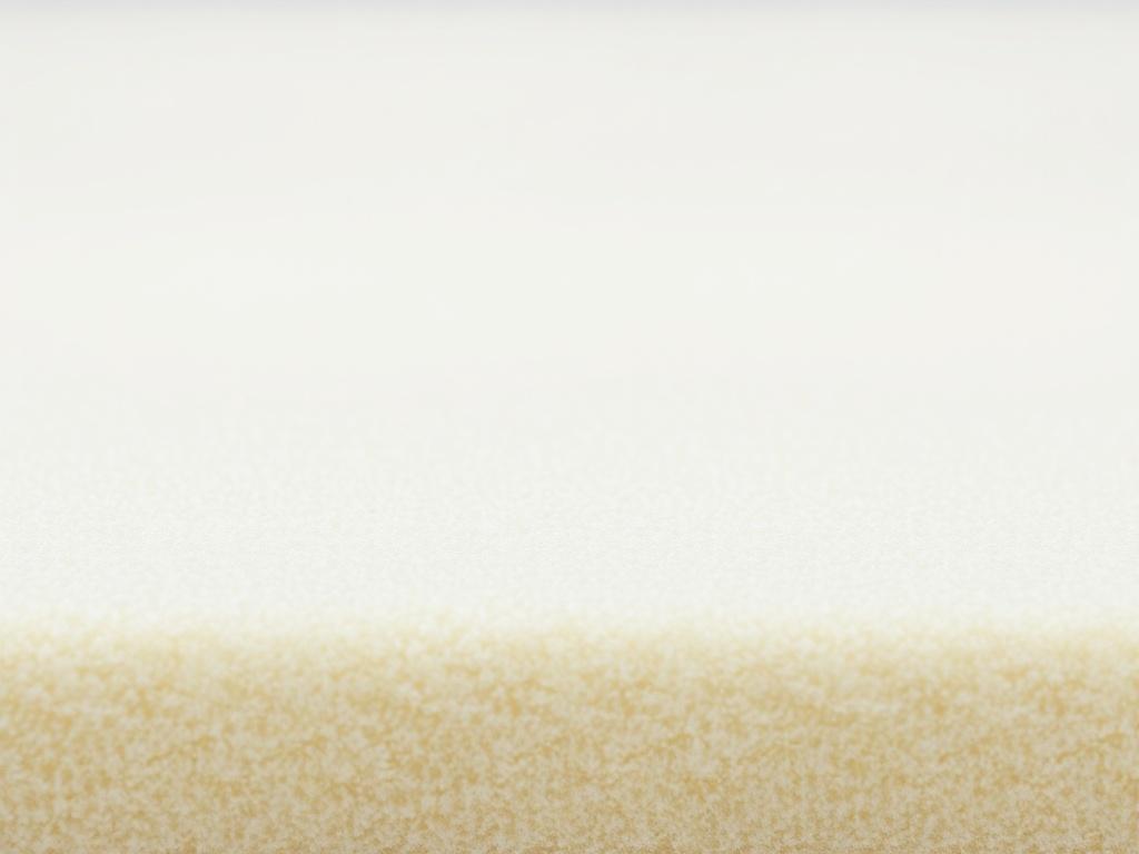 A hyper-realistic close-up shot of Colombian acoustic foam, showcasing its texture and density. The foam should be the only subject in the image, with a simple white background to emphasize its features. The foam should appear soft yet sturdy, with visible contours and a rich color that reflects its high quality. The lighting should be soft and natural, highlighting the foam's details and creating a warm, inviting feel.