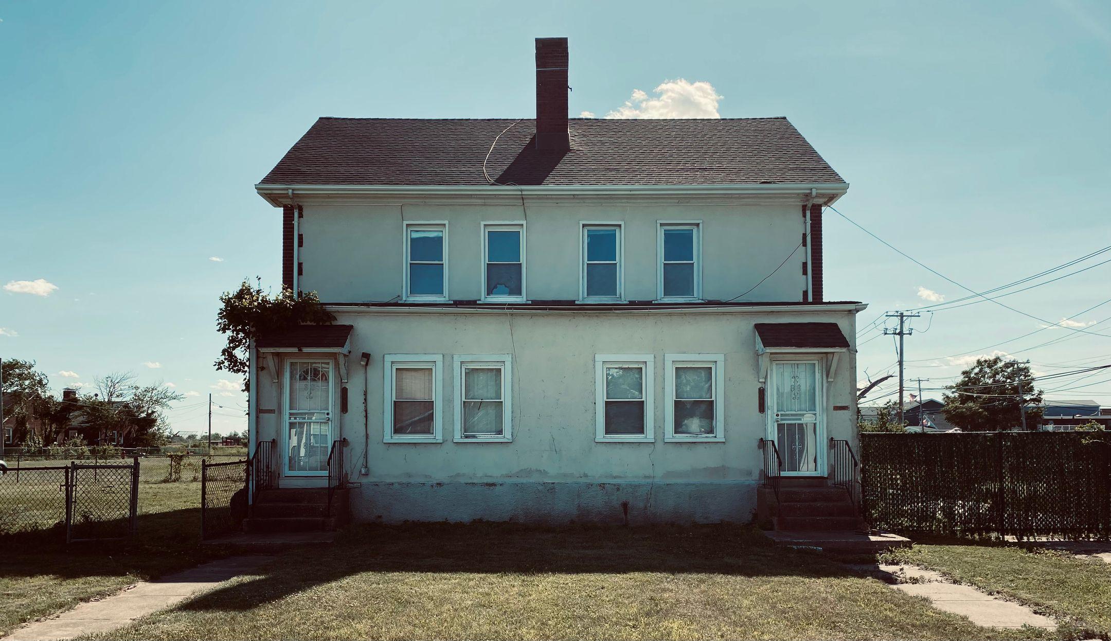 Classic two-story house with vintage exterior design under a clear blue sky.