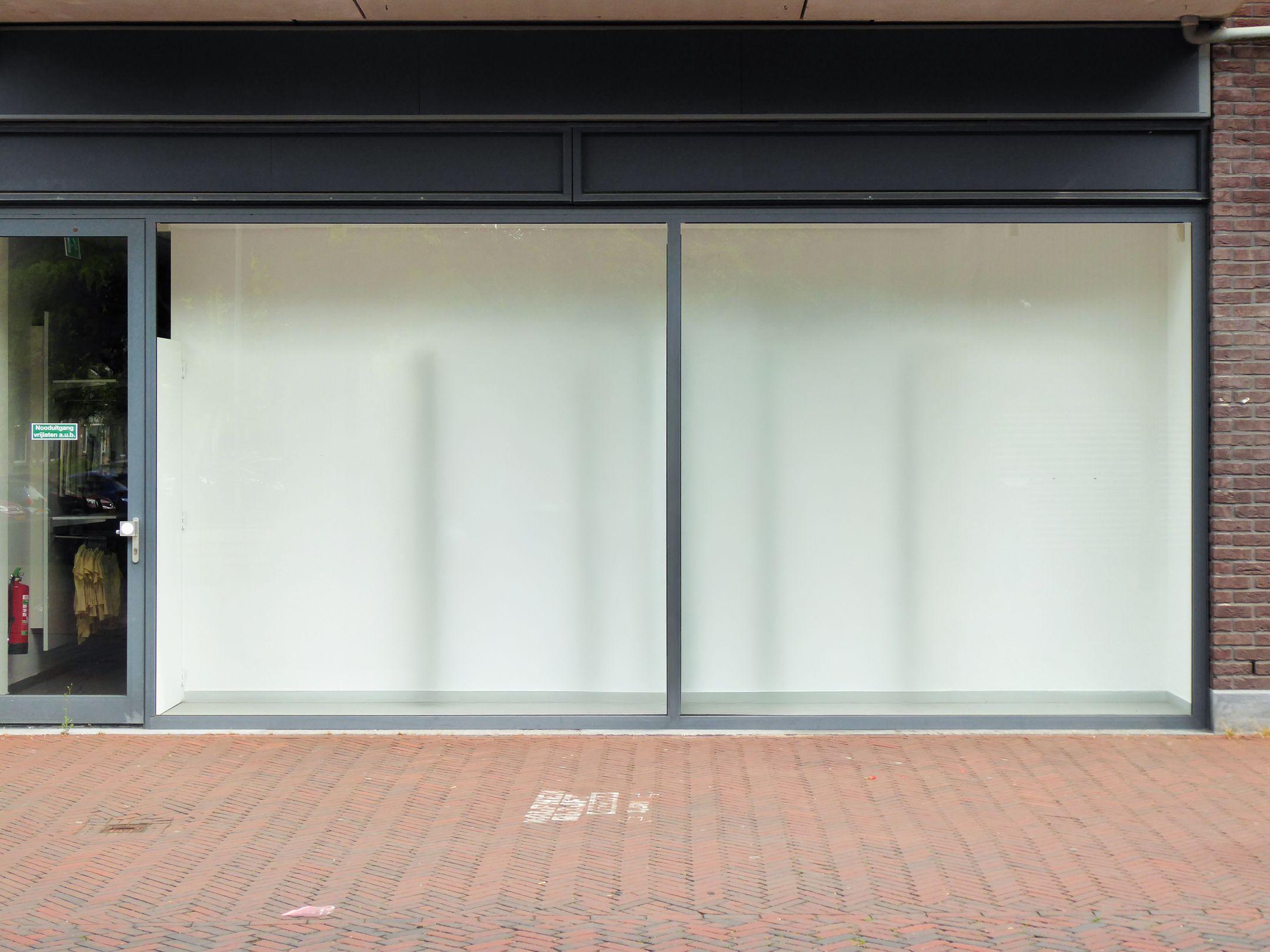 Clean modern storefront with large glass windows, perfect for retail display.