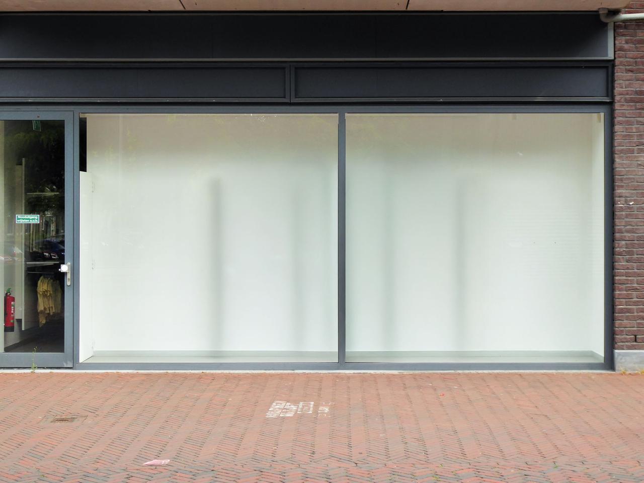 Clean modern storefront with large glass windows, perfect for retail display.